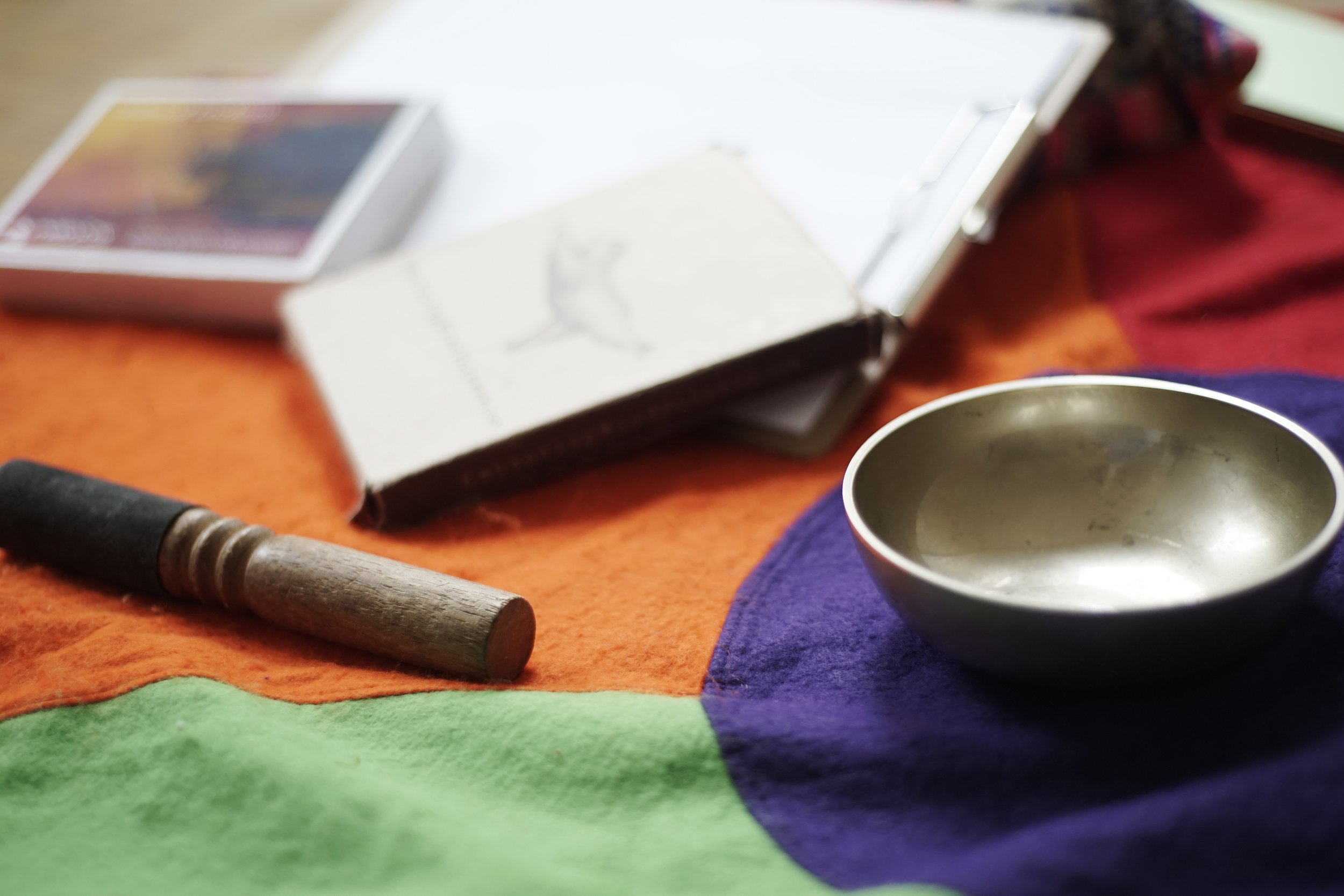 Klangschale und Bildkarten auf buntem Teppich