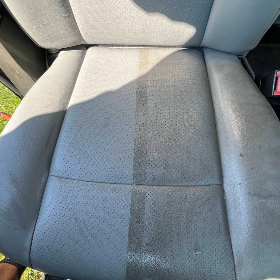 Car seat with water stain or discoloration in the middle section.