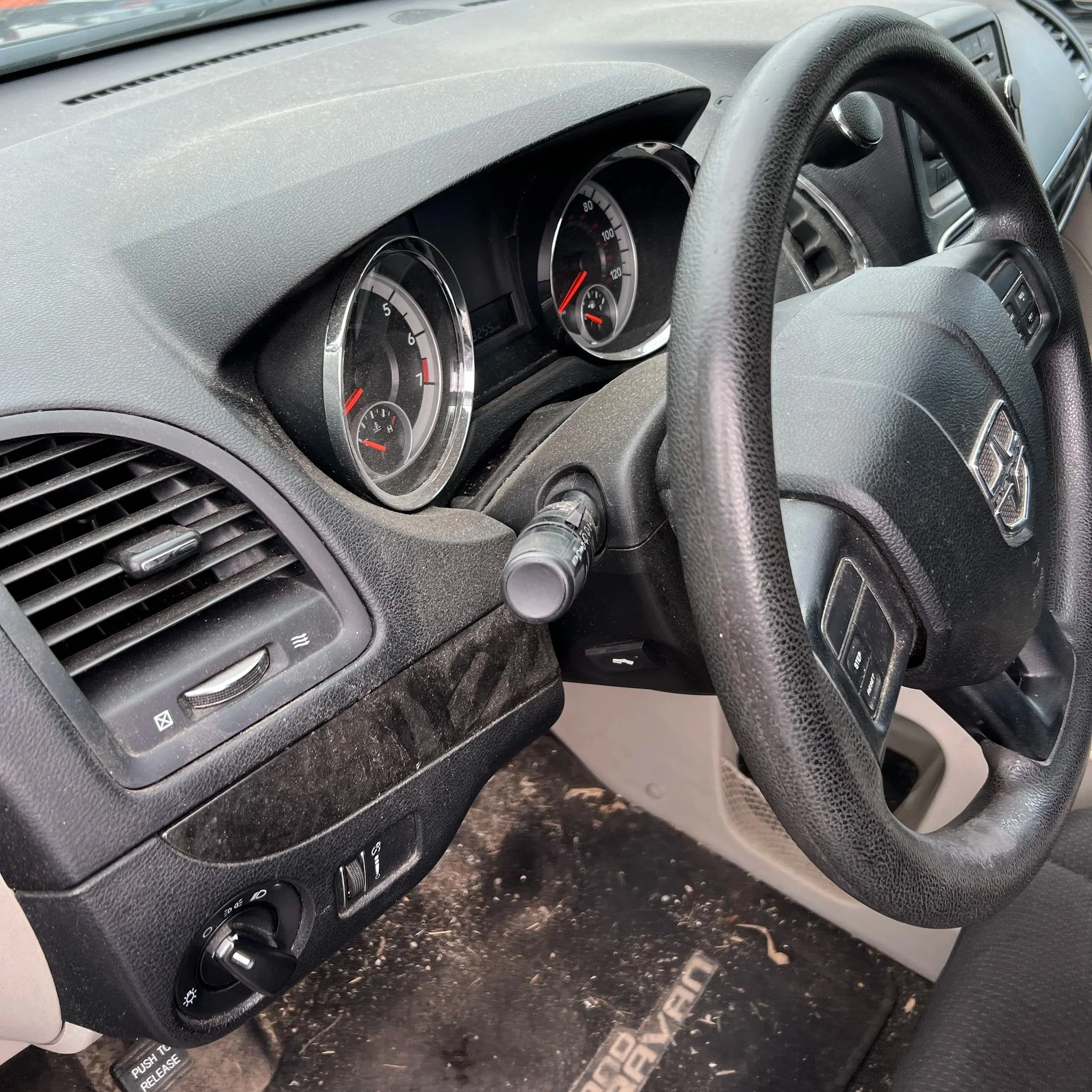 Interior of a vehicle showing the dashboard, steering wheel, and instrument gauges, including speedometer and fuel gauge.