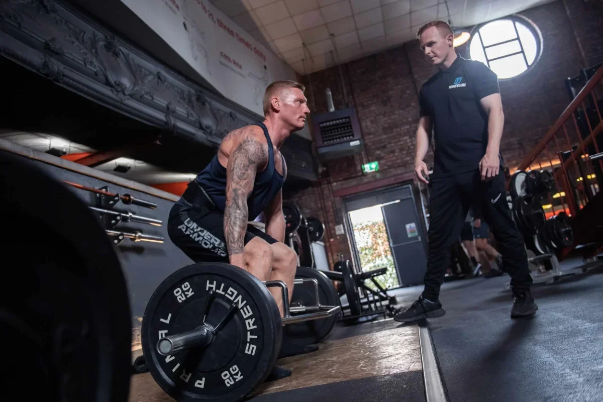 A Fitasylum personal trainer monitoring a client