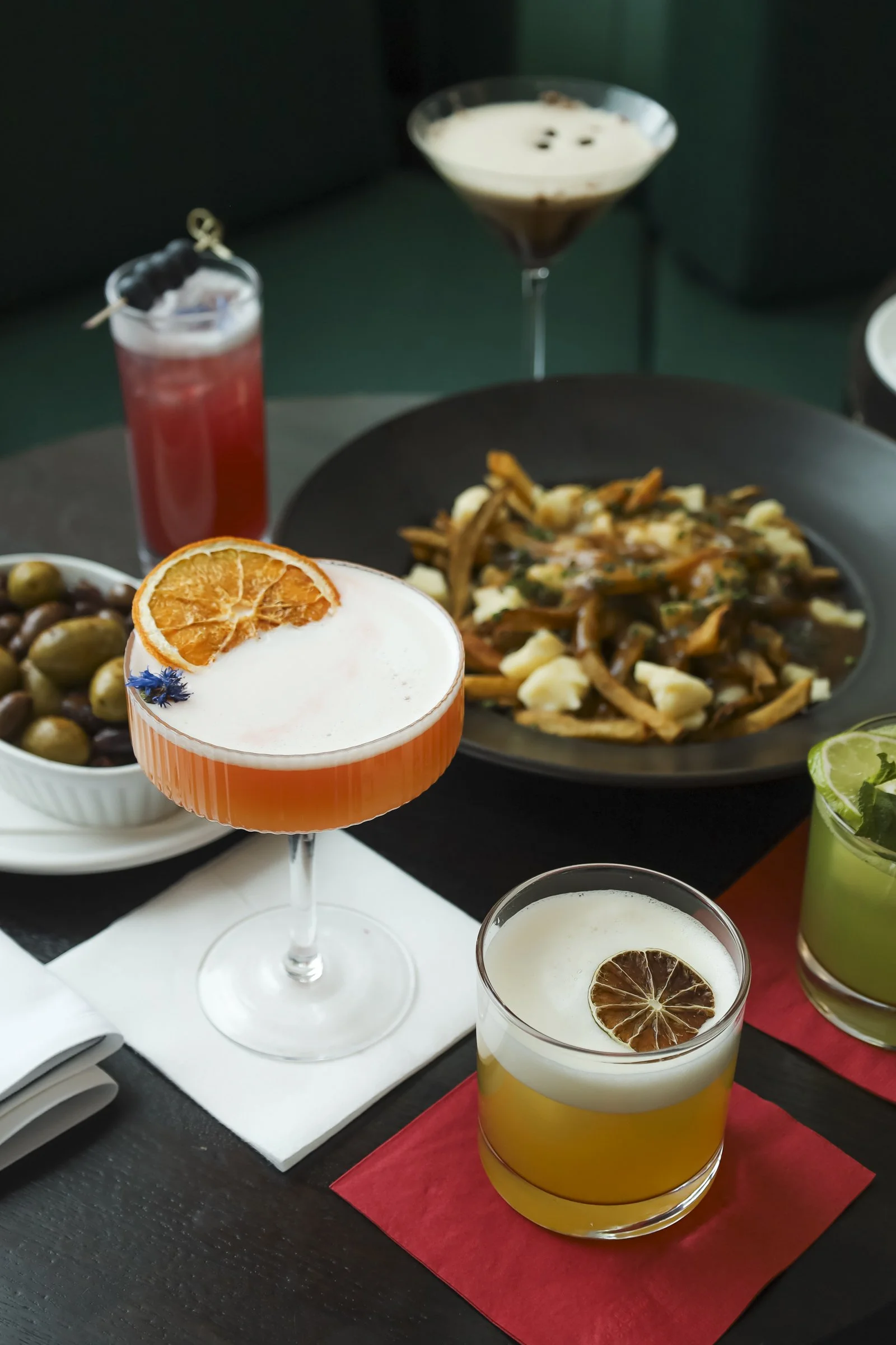 Colorful signature cocktails and shareable plates served at a British pub Montreal in Old Montreal, capturing the vibrant Montreal bar atmosphere and authentic Montreal local atmosphere of a lively Old Montreal pub.