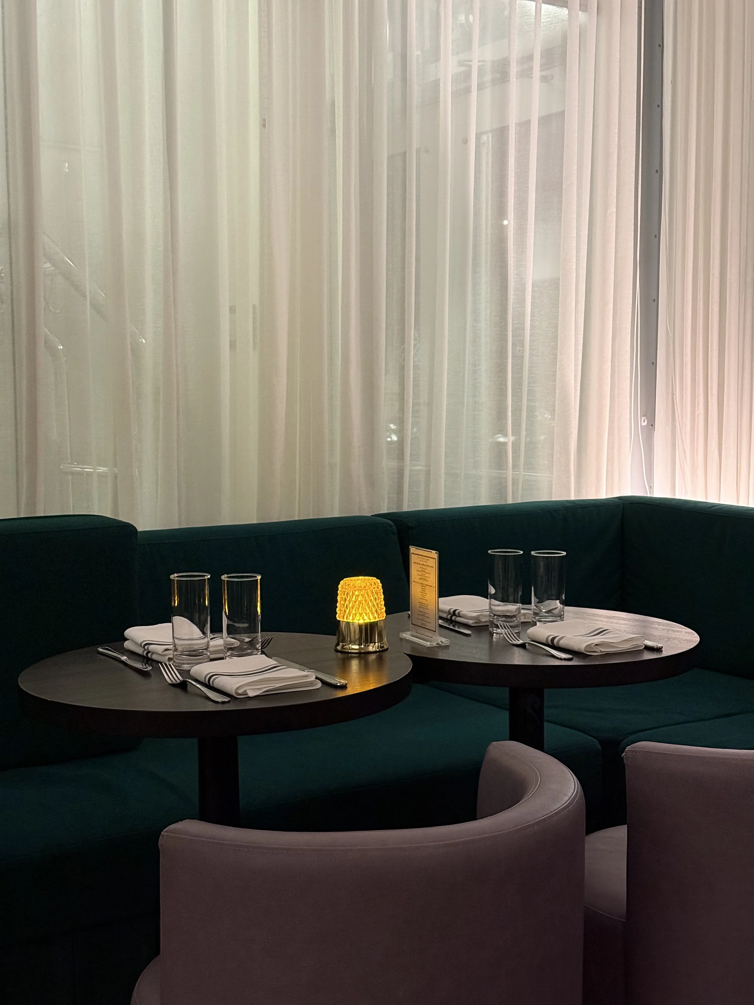 Intimate dining corner with candlelit tables and plush seating at a British pub Montreal in Old Montreal, reflecting the warm Montreal local atmosphere of a welcoming Montreal restaurant Old Montreal.