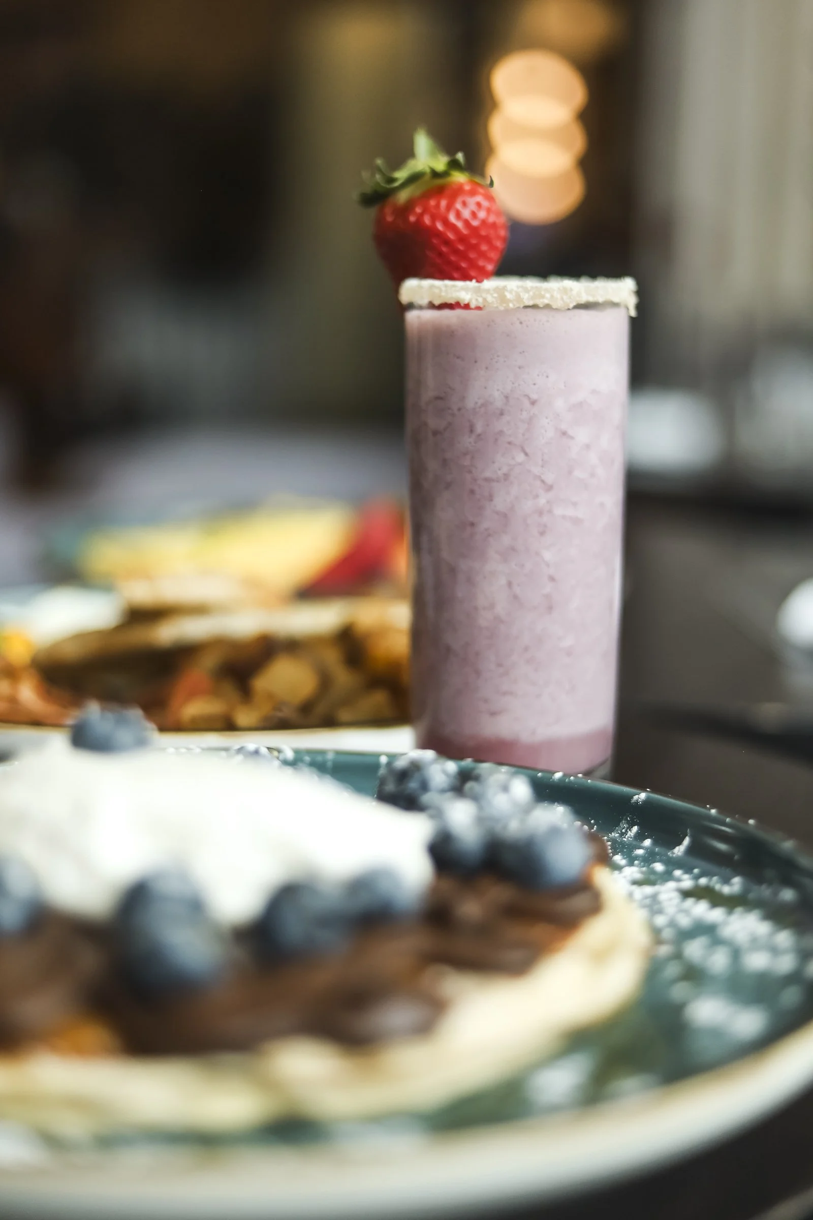 Fresh strawberry smoothie served with brunch in a bright Old Montreal pub, highlighting the welcoming Montreal local atmosphere of a British pub Montreal and restaurant in Old Montreal.
