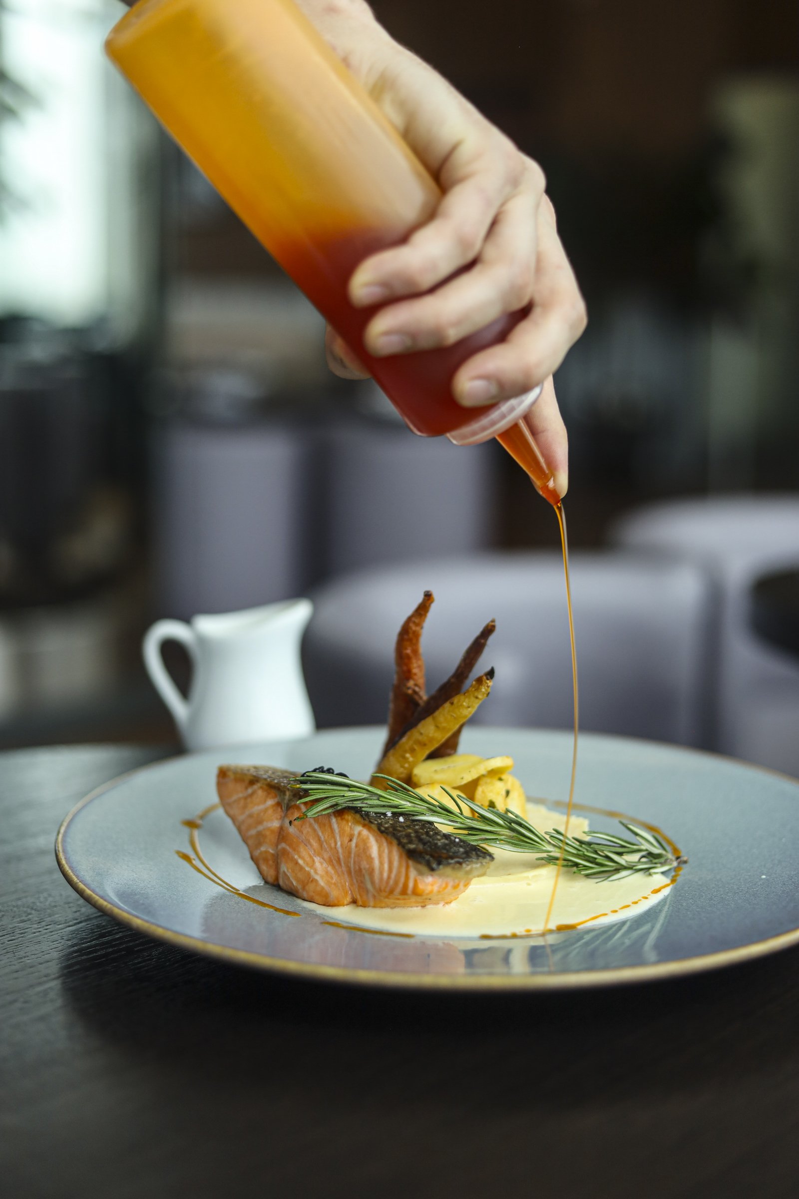 Pan-seared salmon with roasted vegetables and creamy sauce, plated at a Montreal restaurant in Old Montreal, showcasing refined British pub Montreal cuisine in a warm Montreal bar atmosphere.