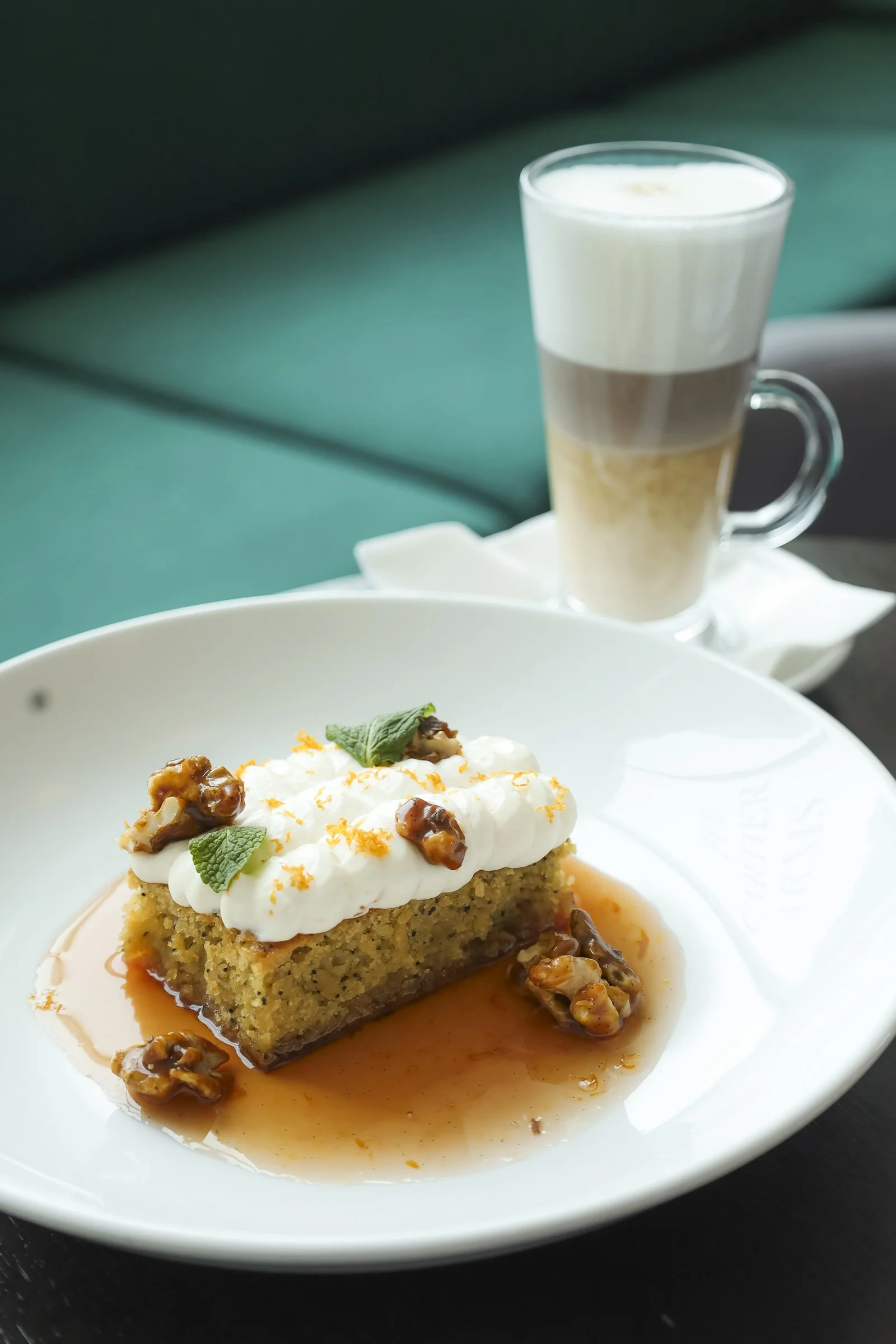 Moist cake topped with cream and caramelized walnuts, served with a latte at a British pub Montreal in Old Montreal, offering a cozy Montreal restaurant Old Montreal experience in a welcoming Montreal local atmosphere.