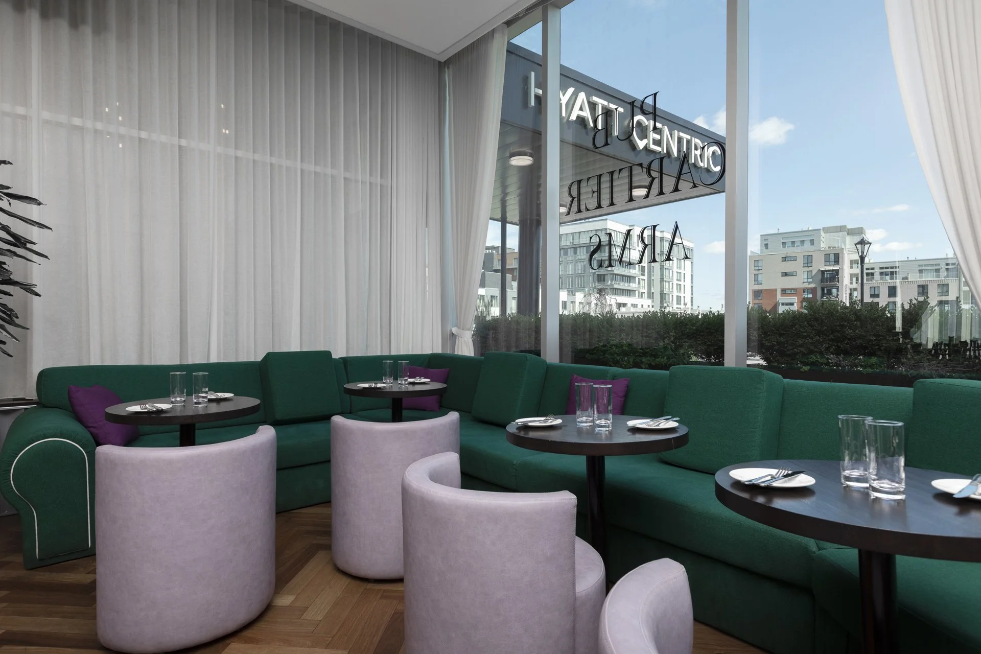 Comfortable lounge seating with large windows at a British pub Montreal in Old Montreal, offering a bright Montreal restaurant Old Montreal setting with a relaxed Montreal local atmosphere near Hyatt Centric Montréal.