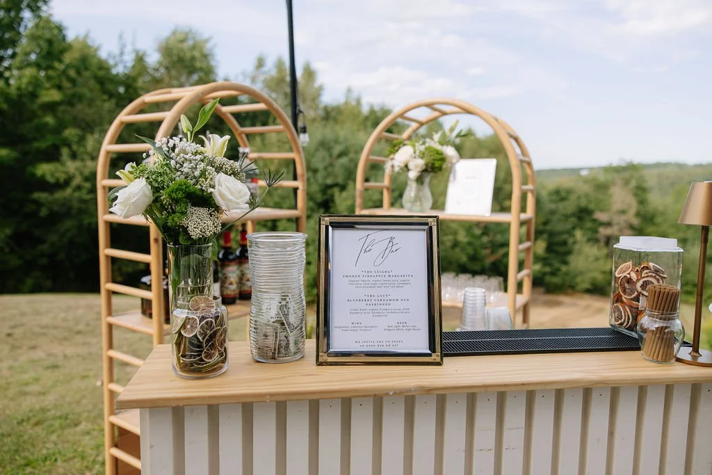 Custom wedding bar setup with styled décor, liquor display, and professional bartending service at reception.