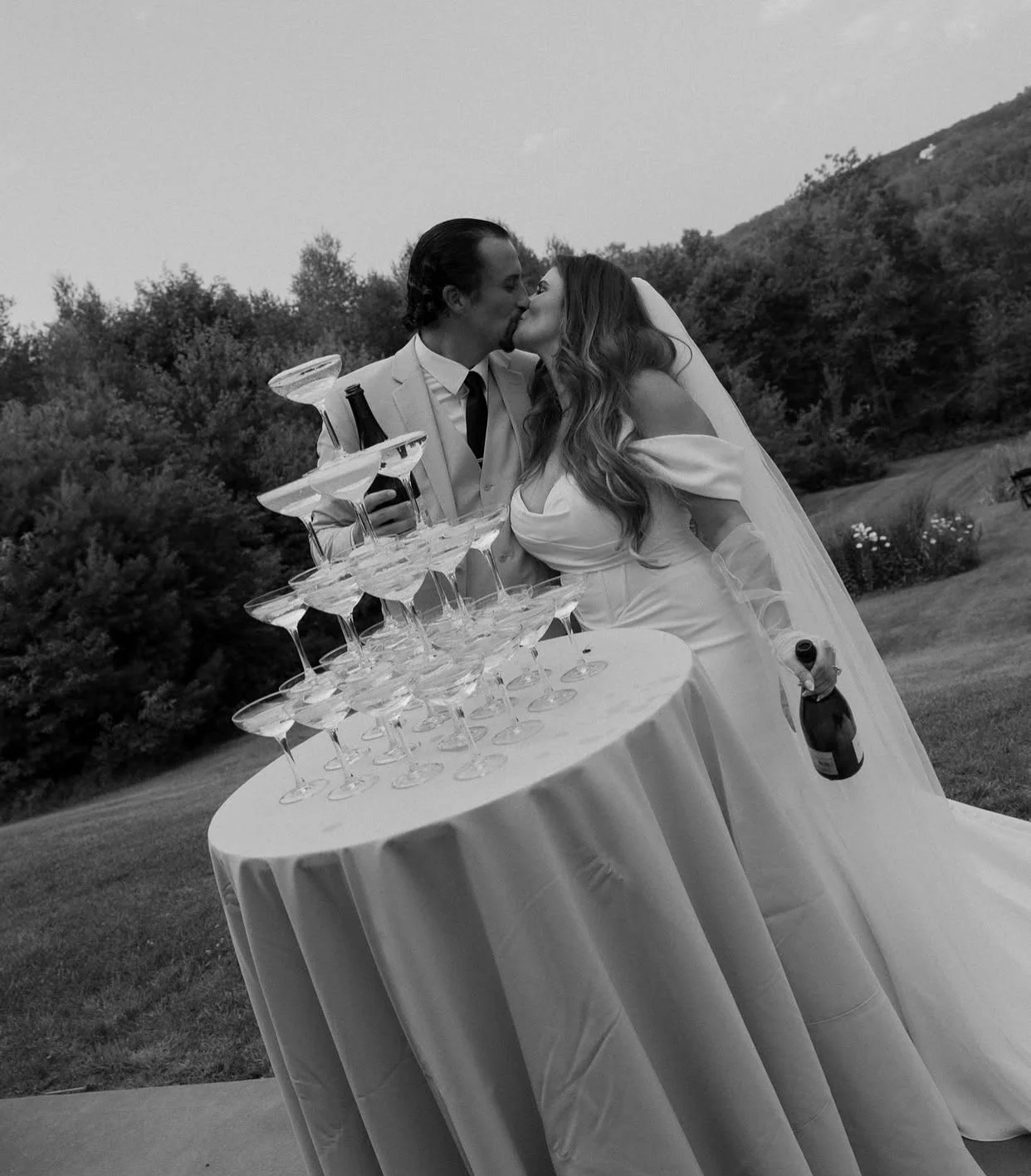 Champagne tower display at a wedding reception with stacked coupe glasses ready for a celebratory pour.