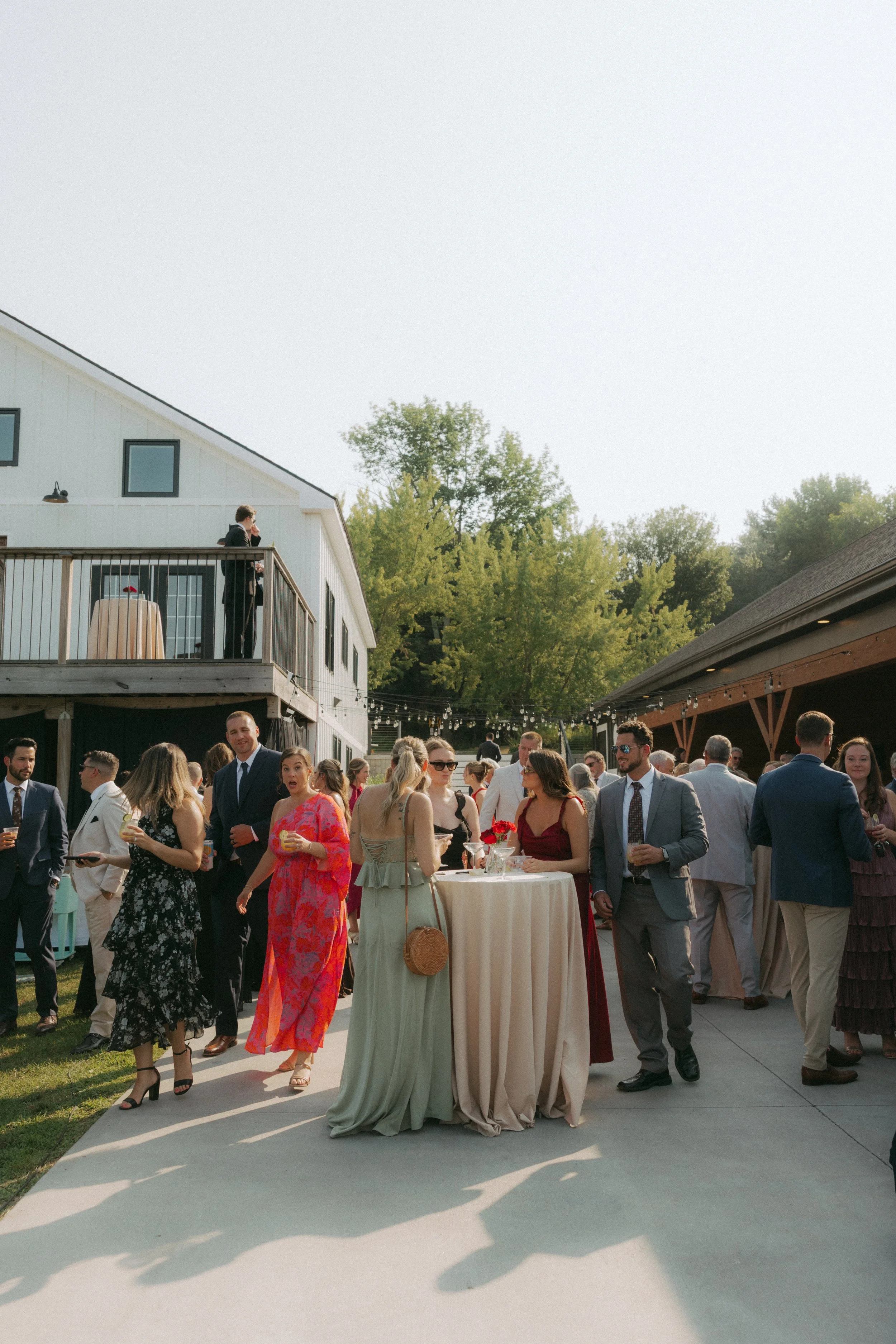 uests mingling during wedding cocktail hour with drinks in hand, enjoying an outdoor reception setting at Moonlit Ridge.