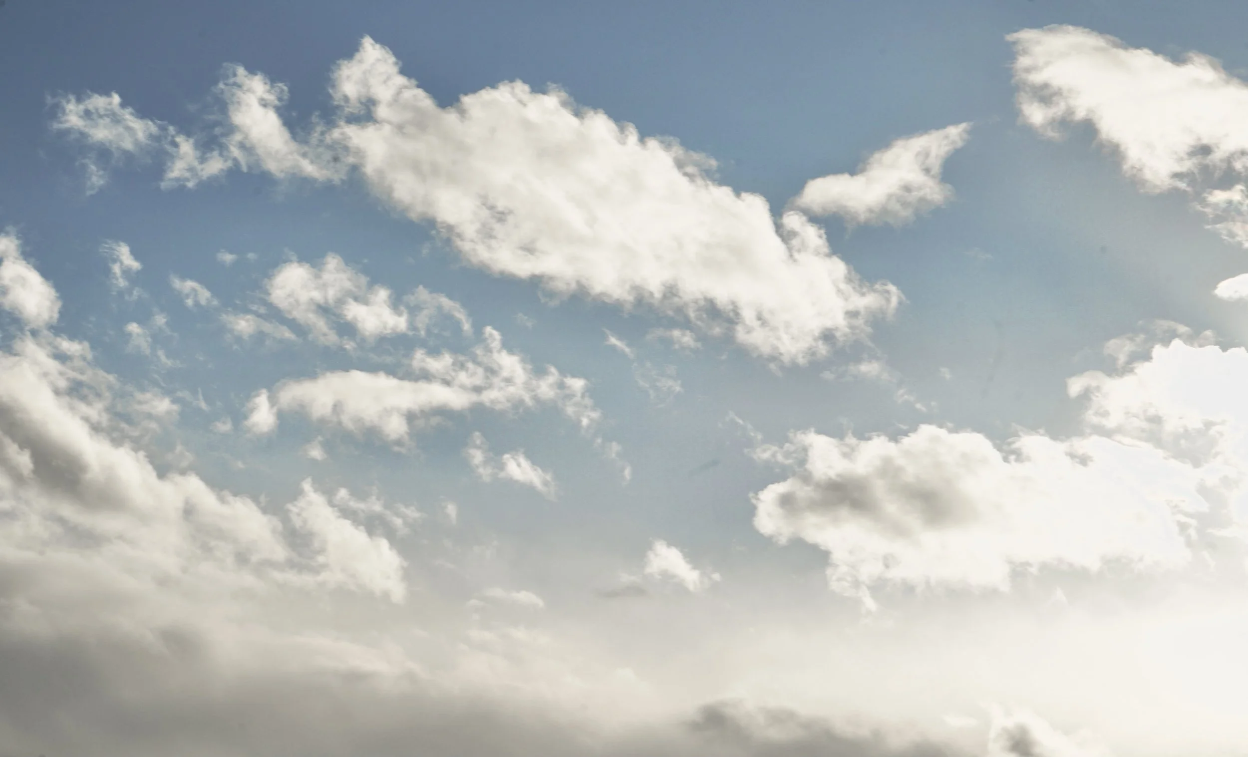 Sky with scattered white clouds during daylight hours.