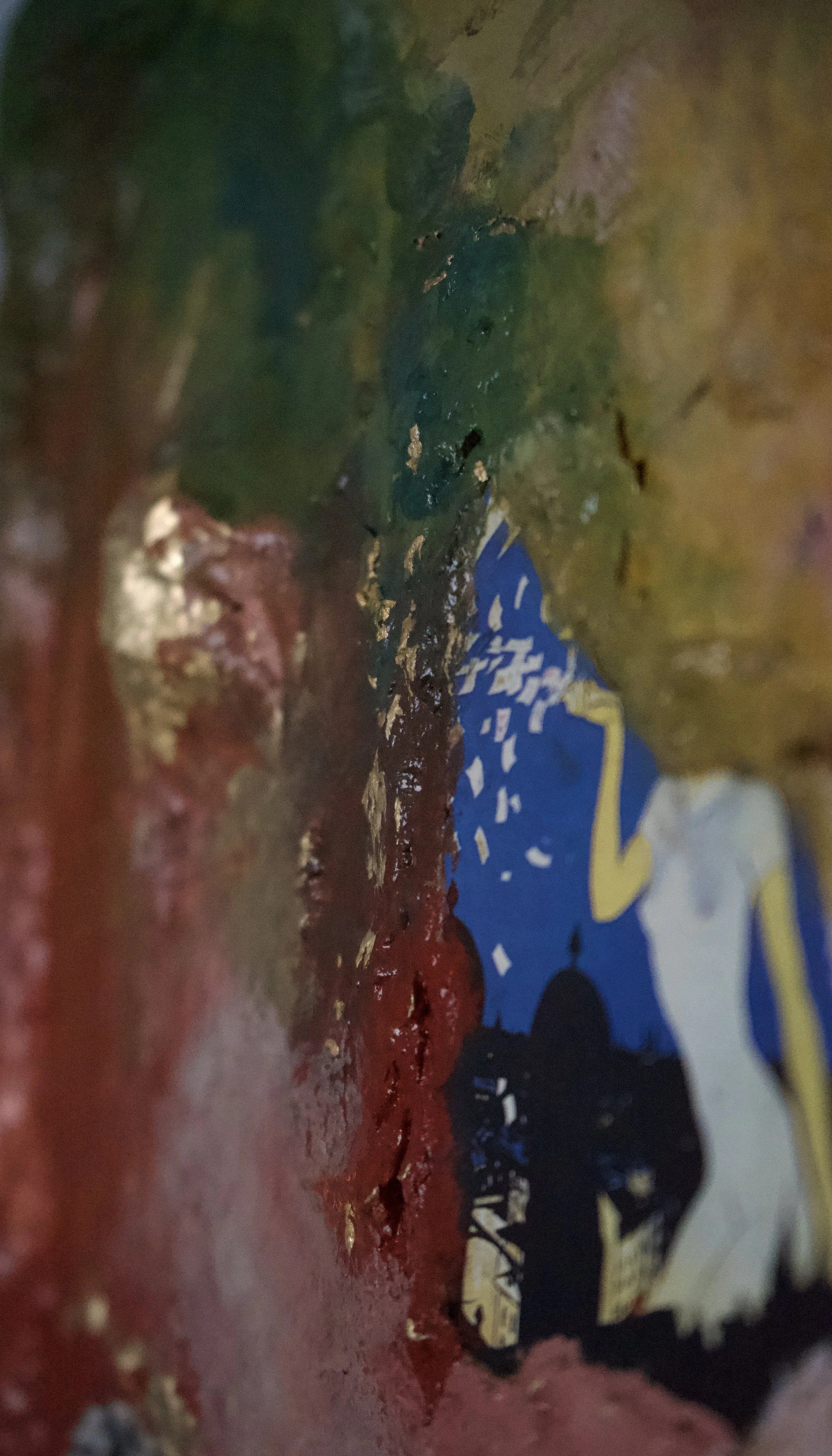 Close-up image of a colorful map or illustration with visible land and water features, including green landmasses, blue water bodies, and some presence of red and yellow colors.