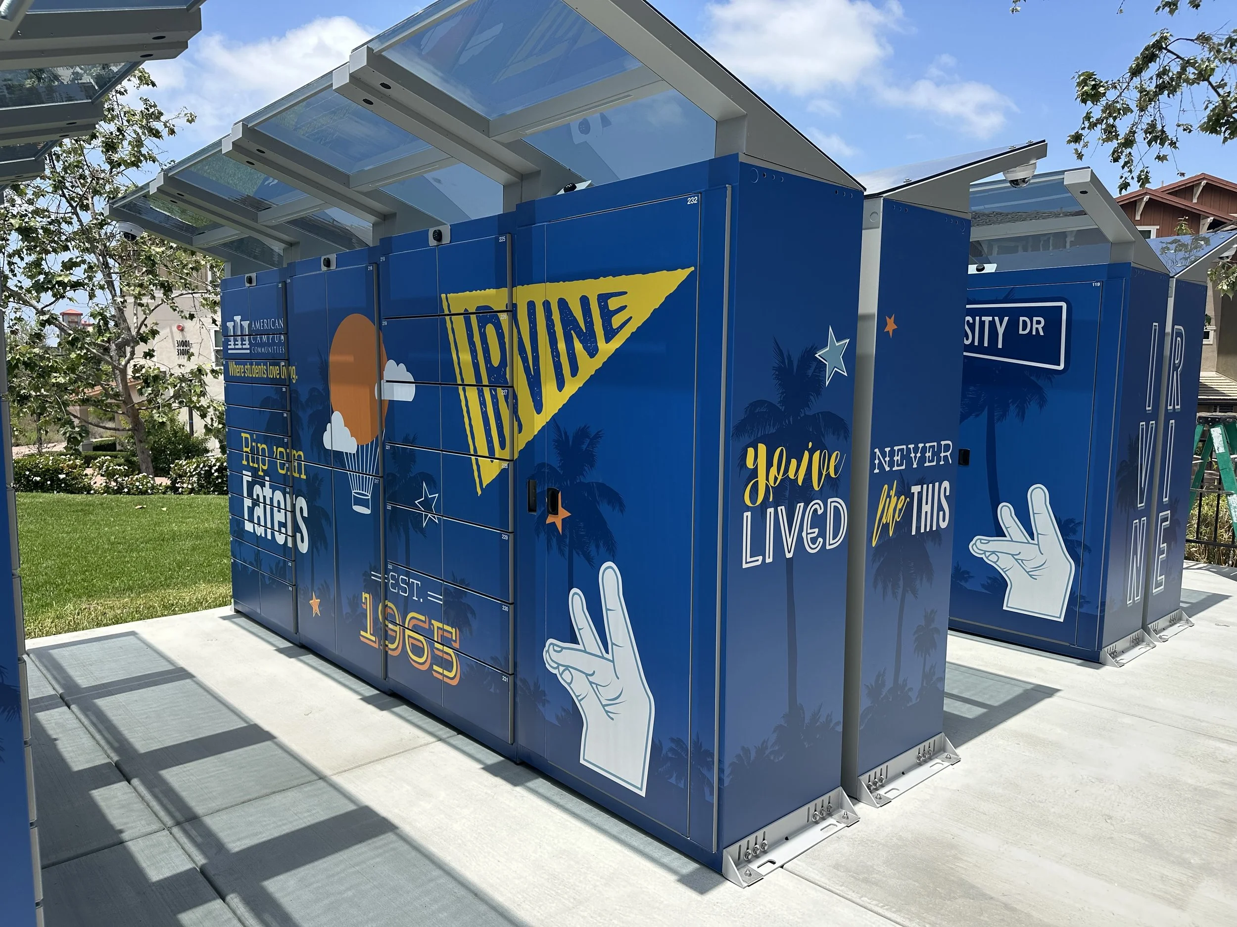 Colorful lockers with a blue background and various motivational quotes and graphics, including a sun, clouds, palm trees, and hand signs.