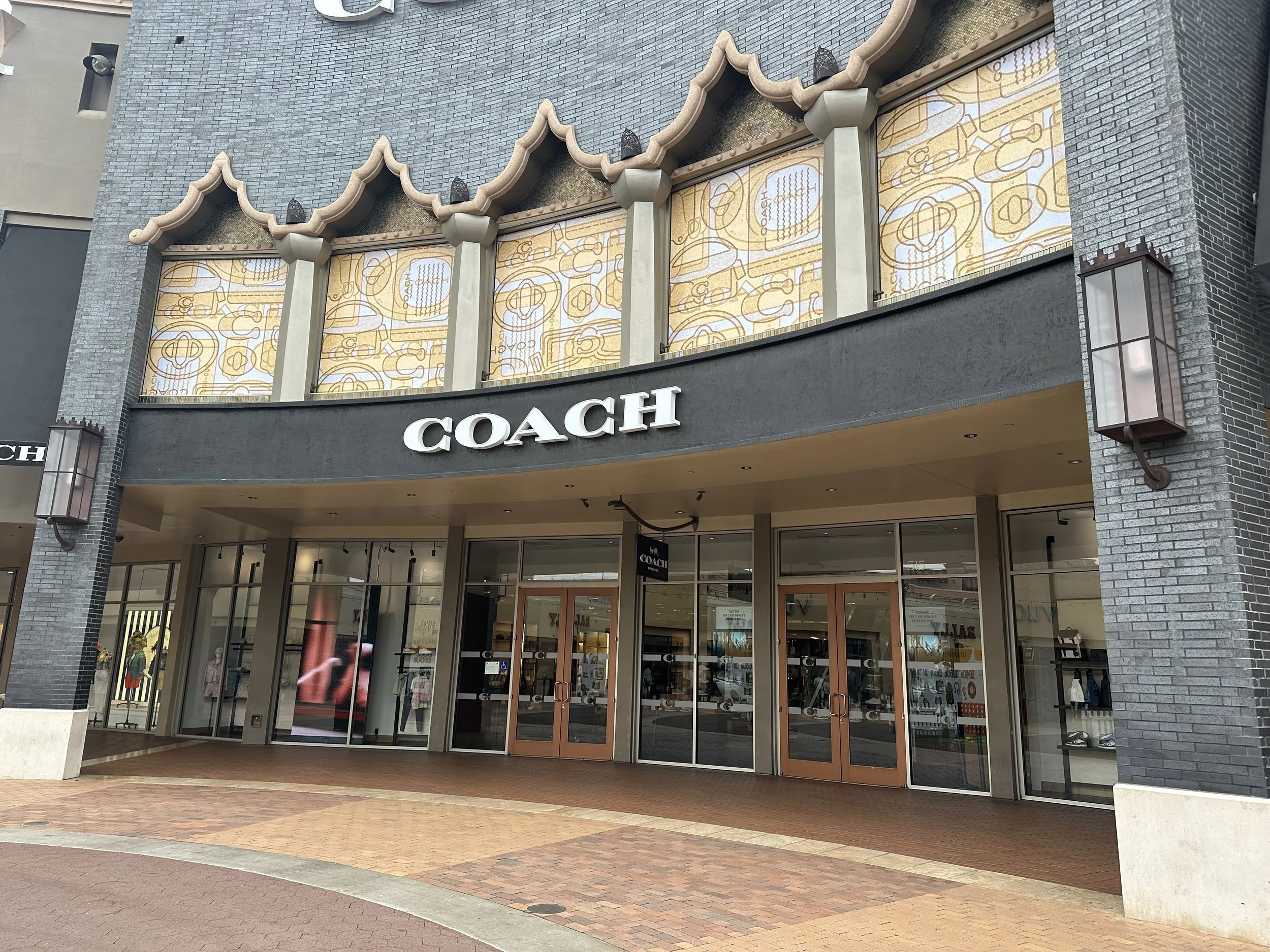 Storefront of a Coach facade showing first surface window graphics