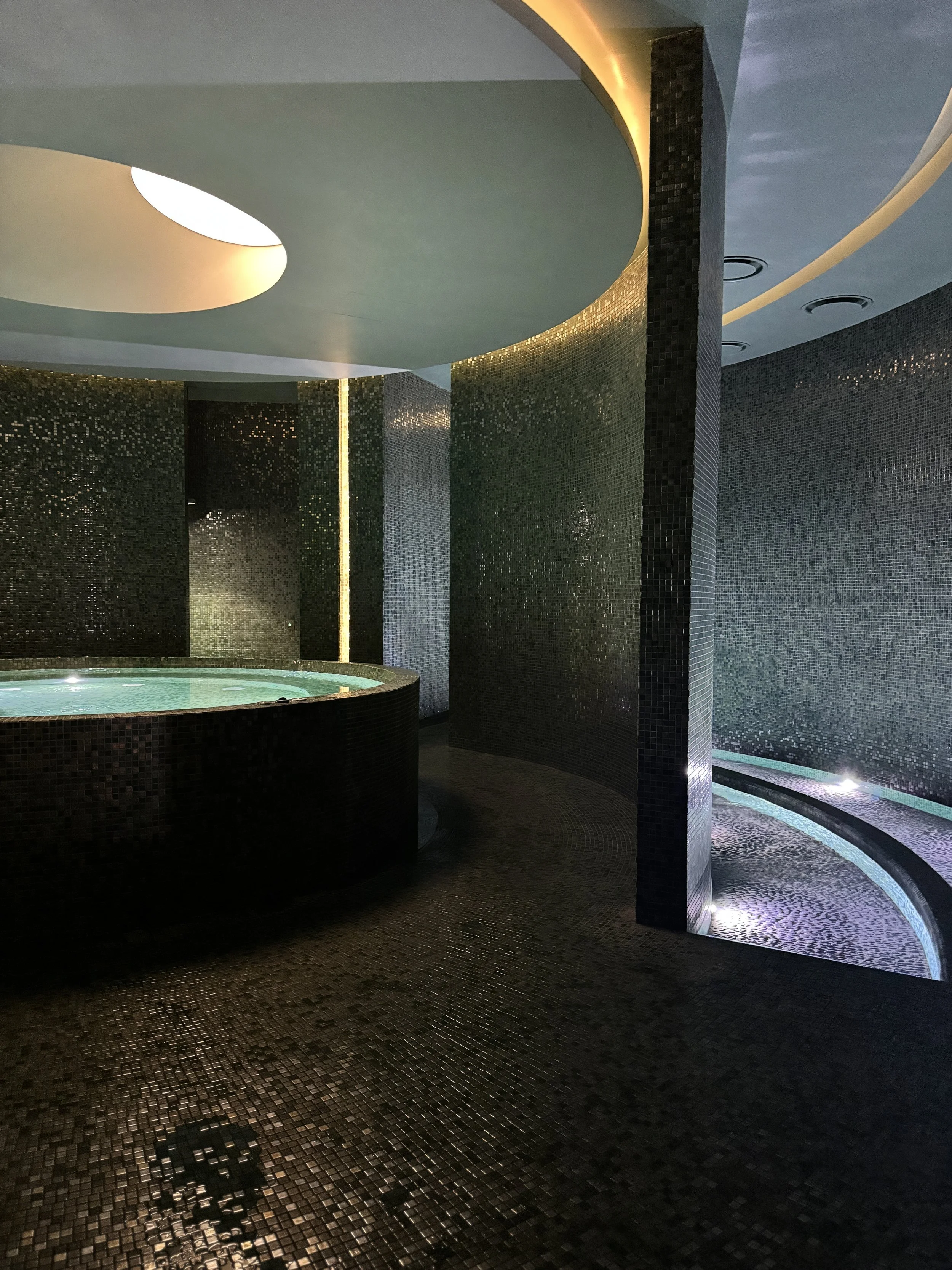 Soft lighting and a calm, minimalist setting create a cocoon-like escape in the soaking tub at the Laurea spa designed for unhurried indulgence.