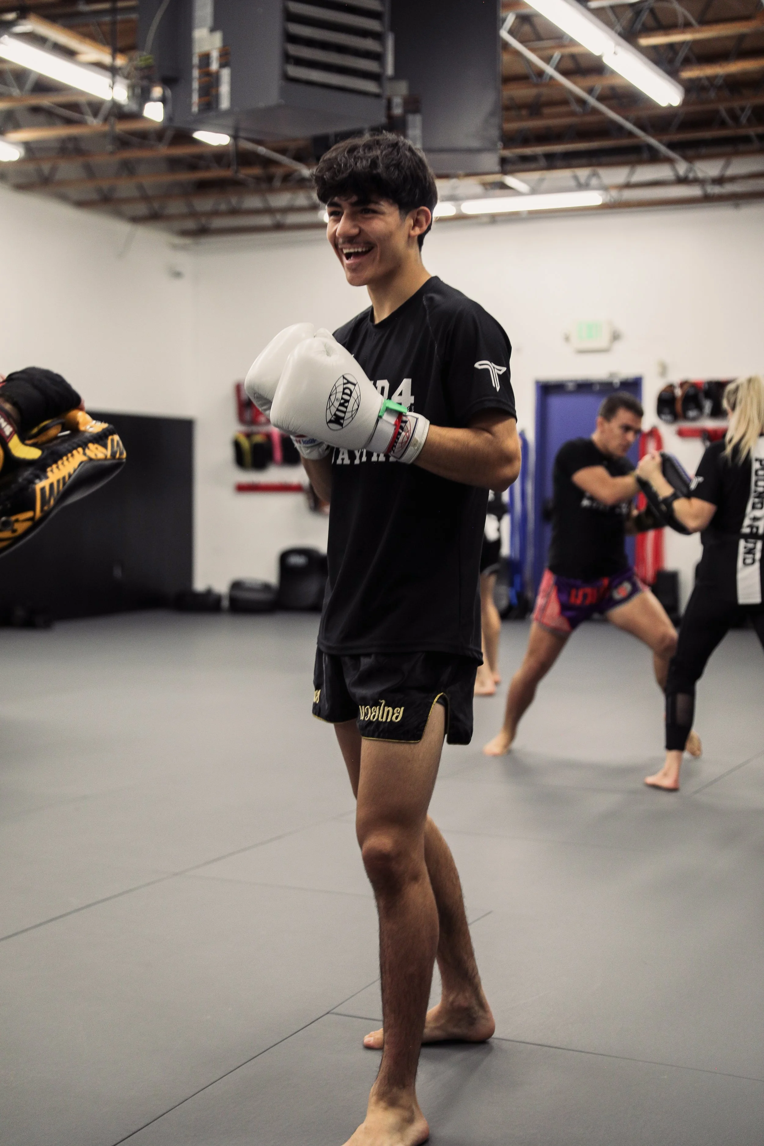 Teen student smiling during Muay Thai class at Pound 4 Pound in Littleton, Colorado