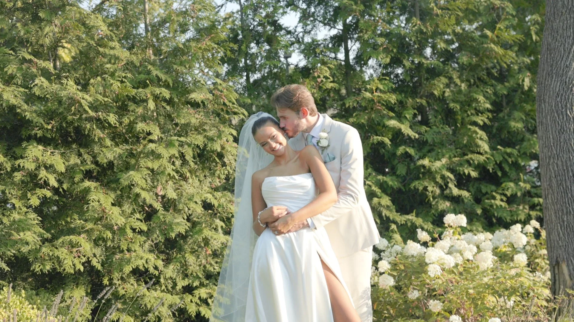 Groom holding smiling bride at waist