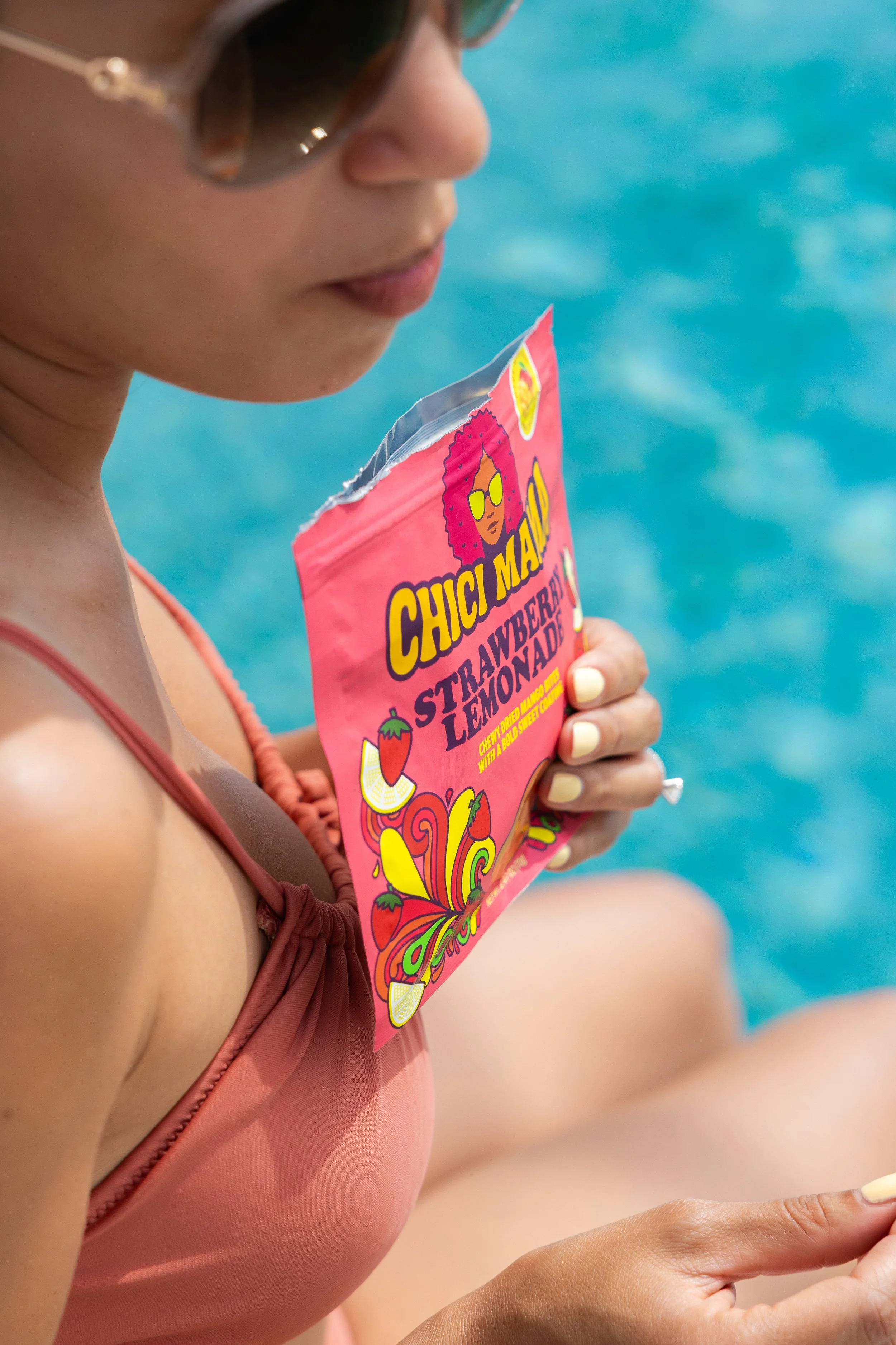 Woman in matching bathing suit holding Chici Mama Strawberry Lemonade snack bag, social media content by Gabe Gonzalez