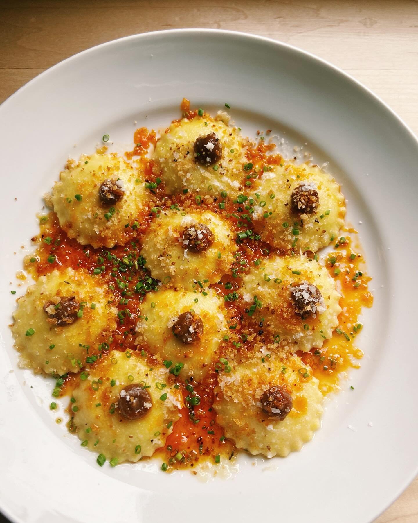 New pasta alert‼️Green garlic ravioli with ricotta, smoked paprika oil, sourdough breadcrumbs, and caramelized onion gastrique