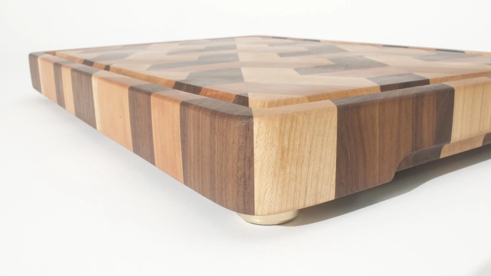 Geometric cutting board with juice groove in walnut, maple, and cherry