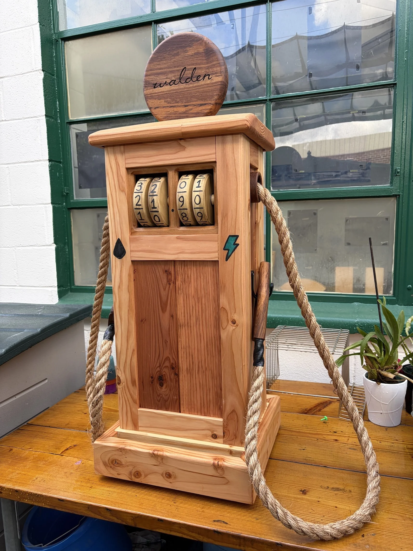 Play gas pump/charging station made of various woods and including spinning number wheels