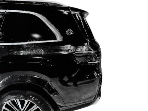 Close-up of the rear side of a black SUV with tinted windows and a visible tire.