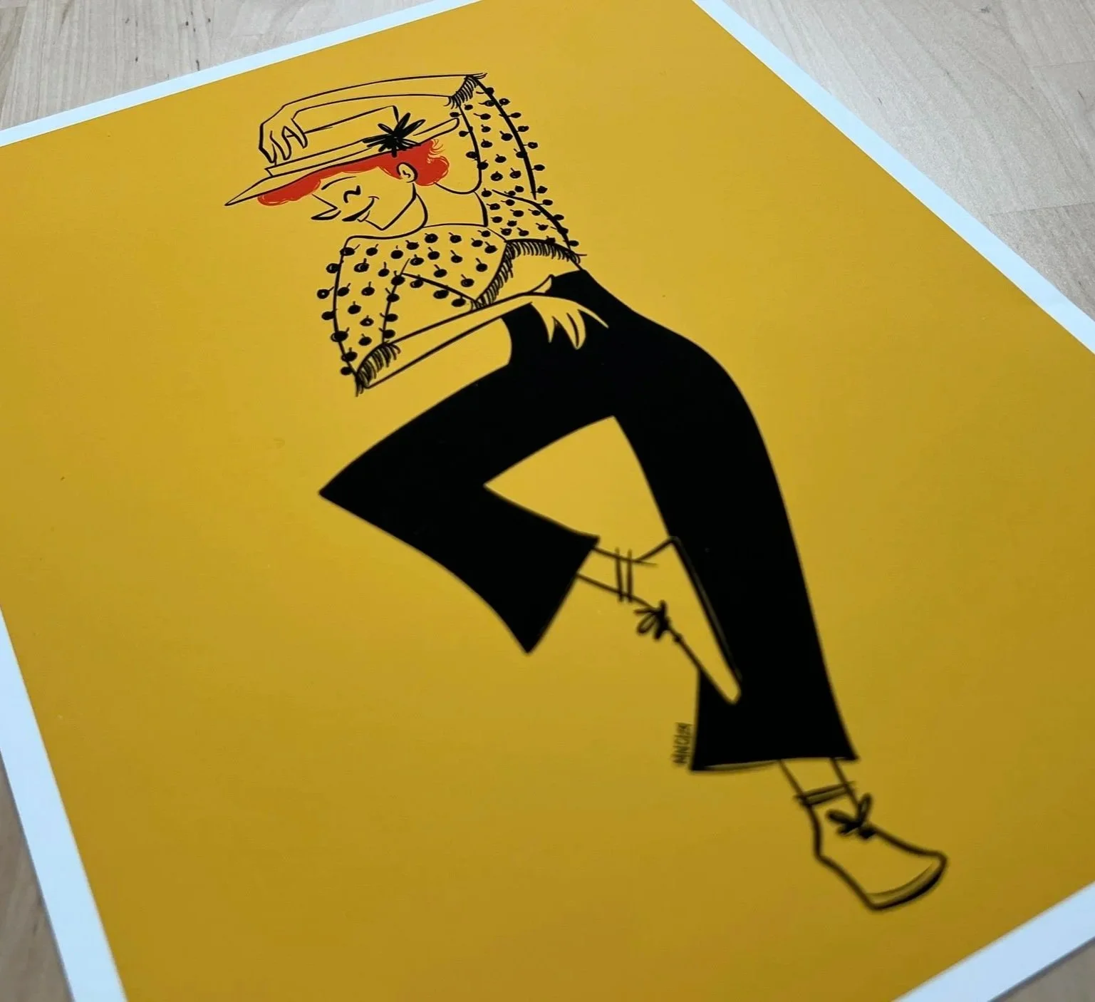 An illustration of Gwen Verdon from the number "Who's Got the Pain?" in Damn Yankees. A woman wearing a hat, a polka-dotted blouse, black pants, and boots, standing against a yellow background.