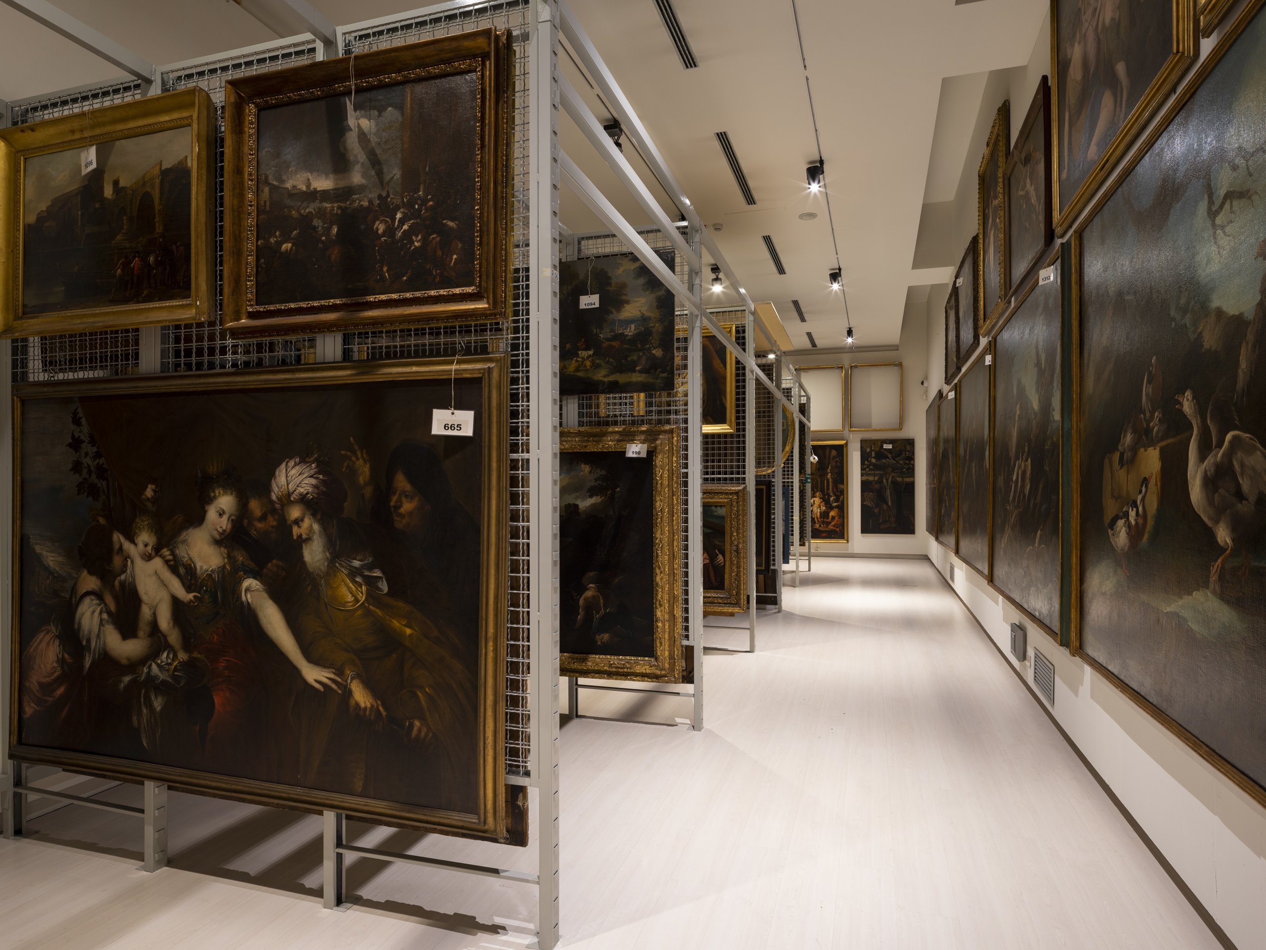 Art gallery with large historical paintings in ornate gold frames on display