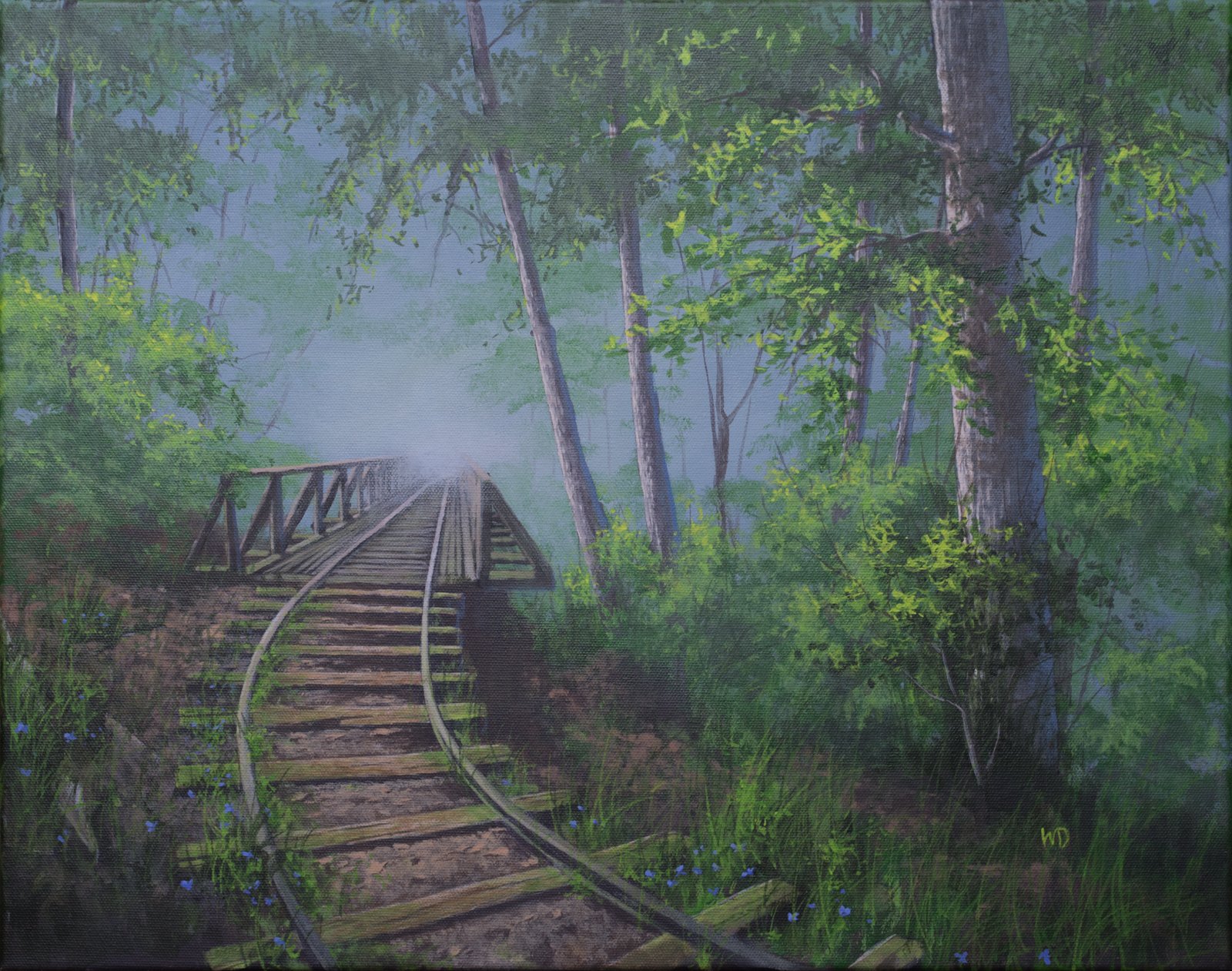old railroad tracks in the forest green grass trees
