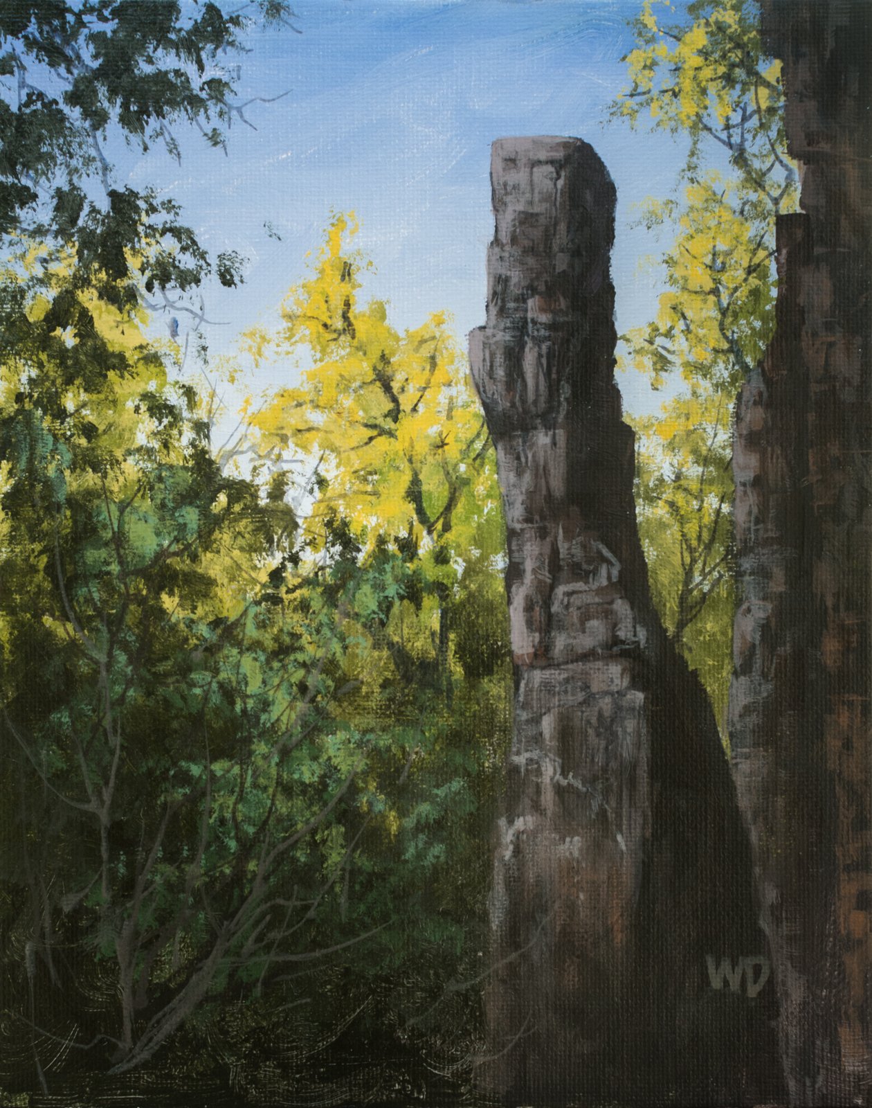 tall chimney rock with green yellow trees blue sky