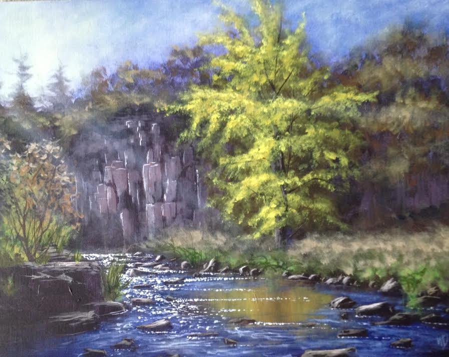 bright green tree on river bank rushing sparkling water under cliff