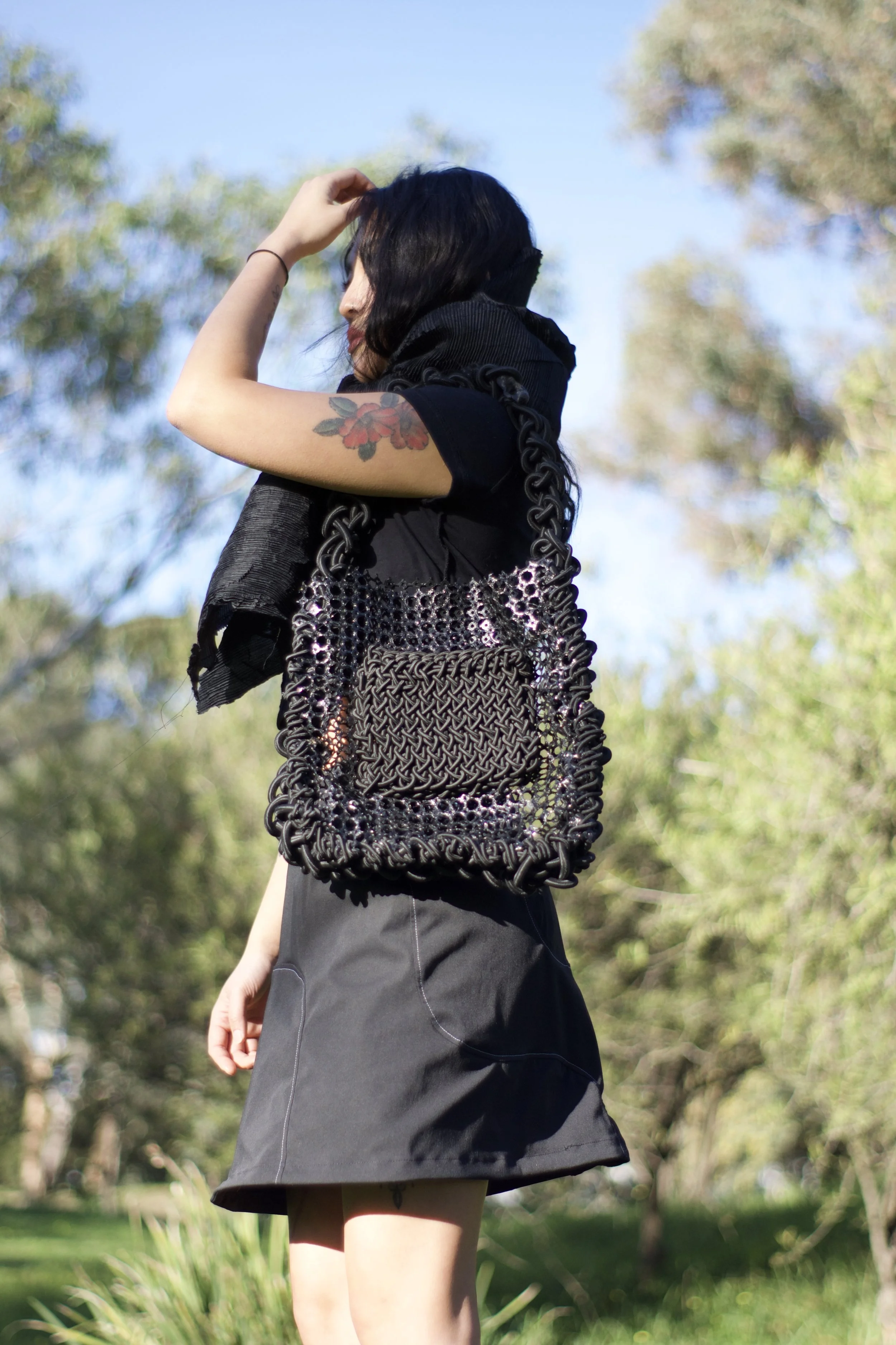 Black pants with white stitching and a black waistband with a buckle.