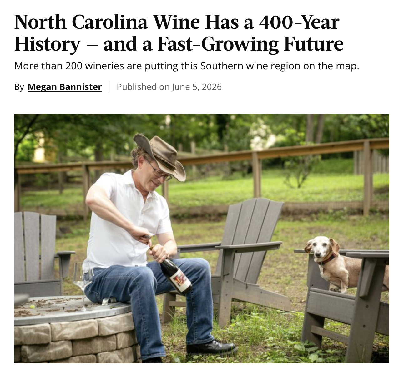 A screen shot of the top of the article showing the title of the article and Erik sitting opening a bottle of wine on the left while Red, a dachshund, sits on a chair to the right in an outdoors scene.