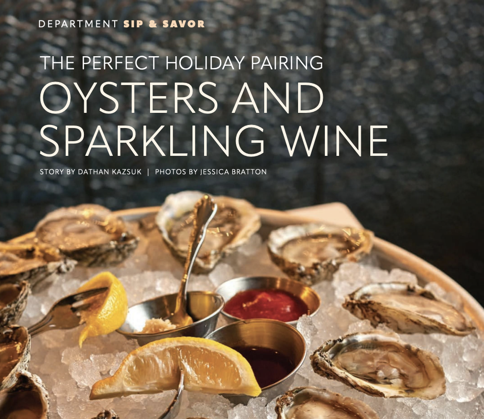 Oysters on ice with stainless steel ramekins of sauce and a lemon slice.