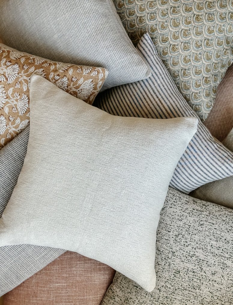 A pile of neutral African handmade cushions