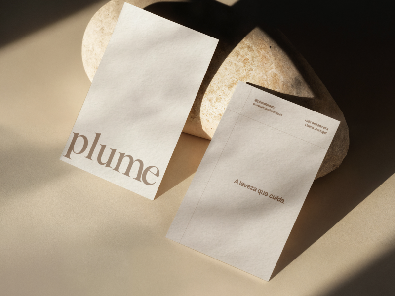 Plume Beauty stationery design featuring two textured ivory cards with an elegant brown serif wordmark, minimalist typography and warm natural shadows, showcasing the brand identity by Out of Form Studio.