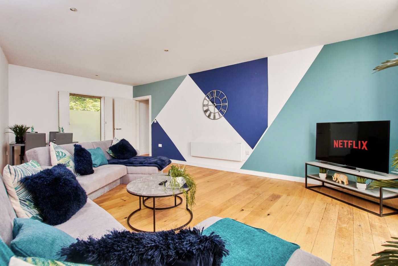 Large lounge with geometric feature wall and TV, staged to increase booking conversion