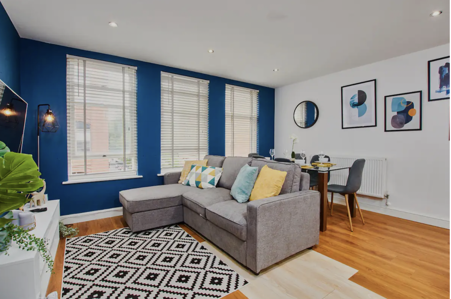 Bright living and dining area with deep blue walls, staged for a high-quality short-let listing