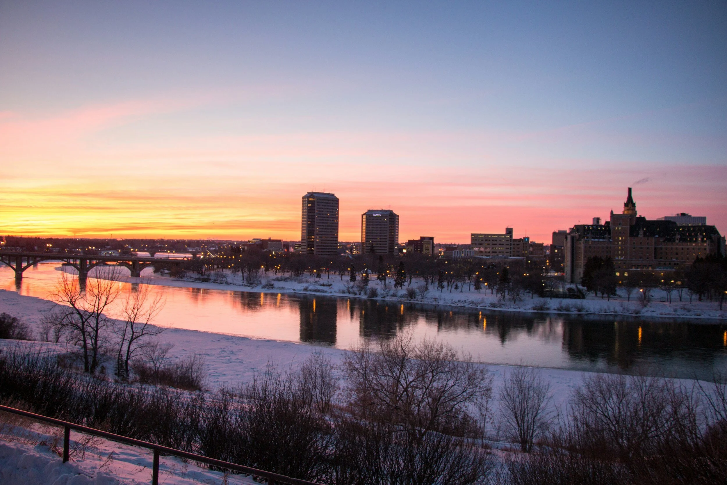 The skyline of downtown Saskatoon, SK at sunset as viewed from across the river