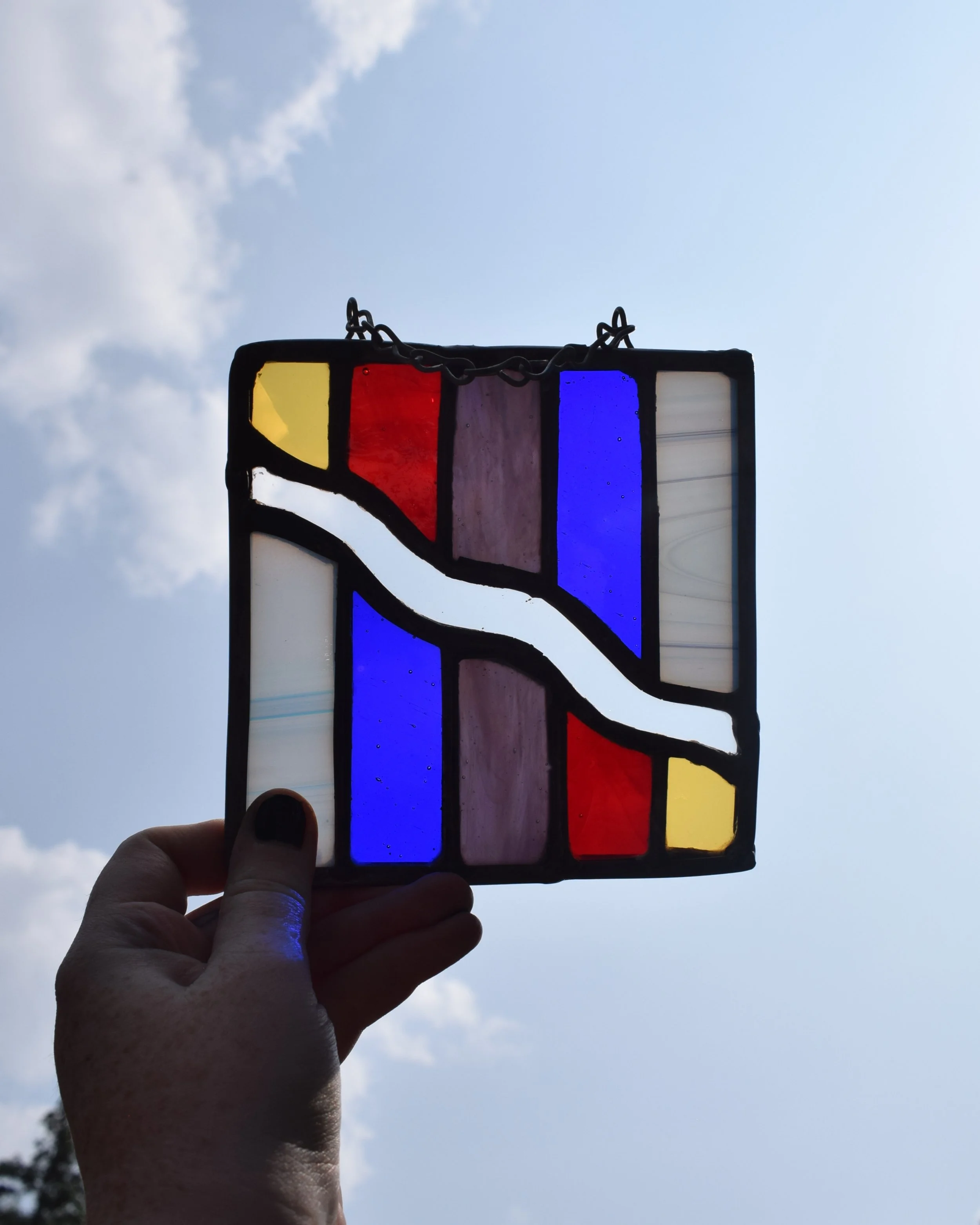 Left over small pieces of glass are so fun to play with, and create shapes and designs that I wouldn't normally do. 
This rainbow wiggle piece is online! 
#stainedglass #abstractart #rainbow #homedecor #artstudio #blackbirdswindow
