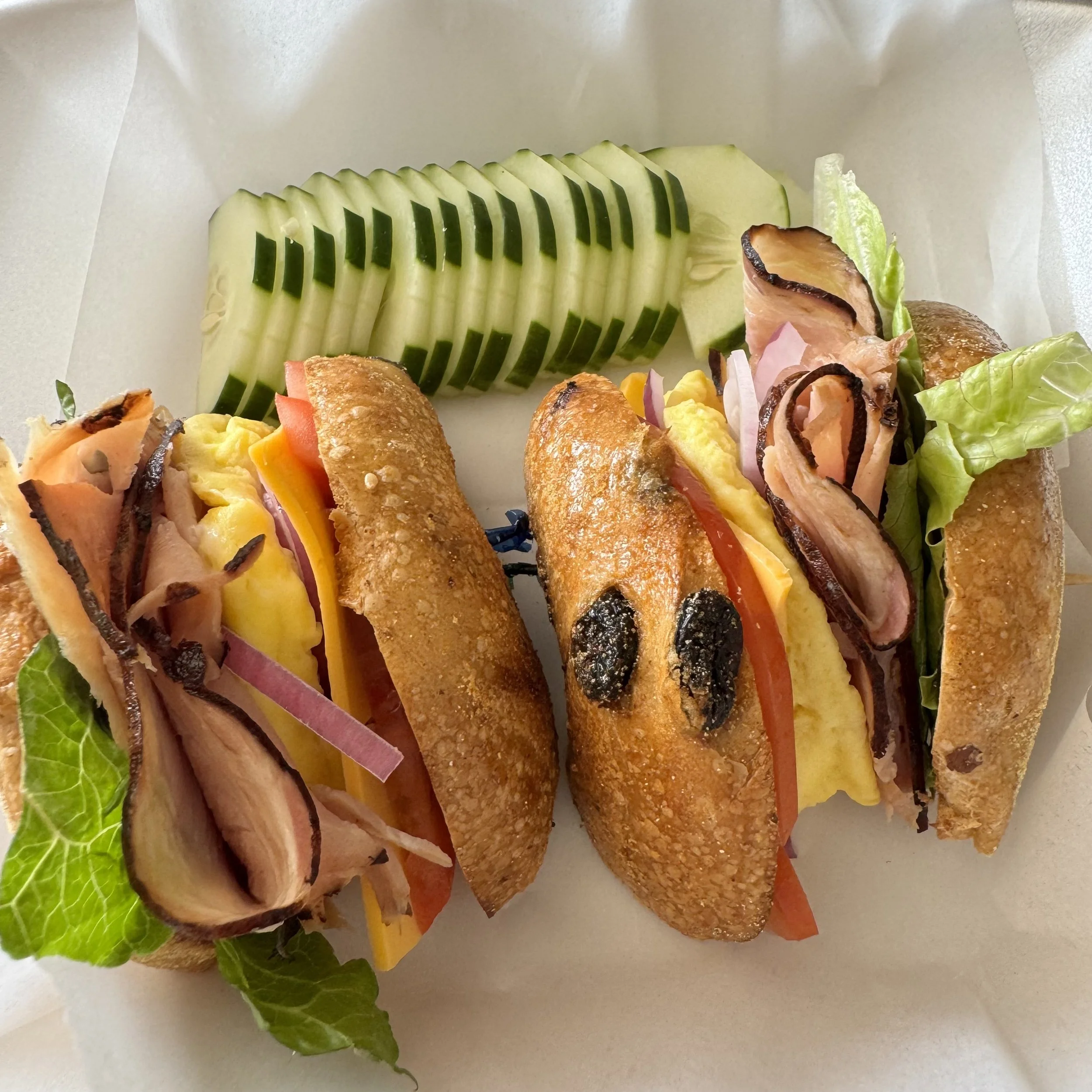 Ham and Cheese with Egg, Lettuce, Tomatoes, and Onion on a cinnamon raisin bagel