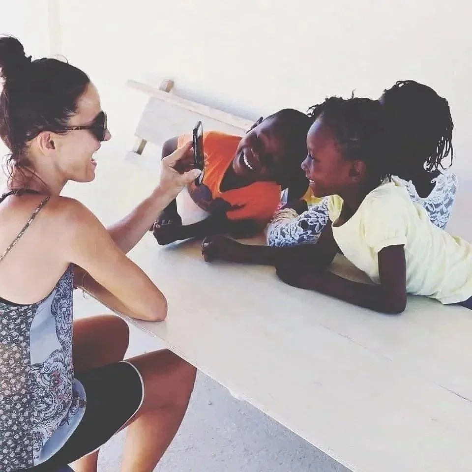 Serena bufalino with children in haiti showing them something on her mobile phone