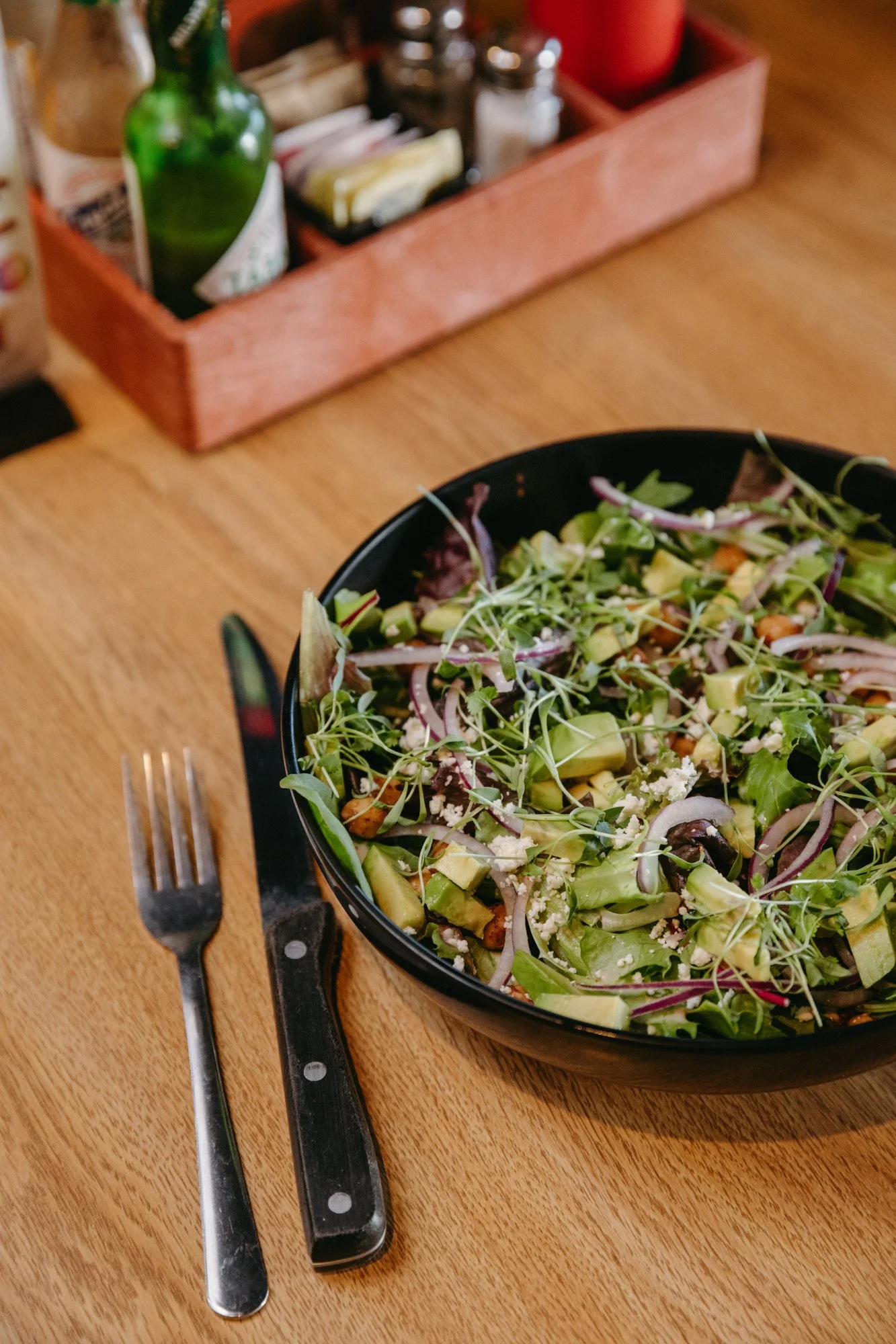 The Chickpea Avocado Salad w/ red onion, feta, chopped avocado, chickpeas, mixed greens, and harissa vinaigrette.