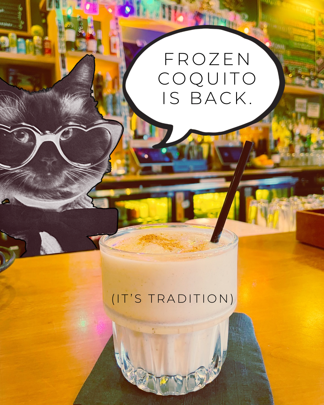 A frozen white drink w/ a dusting of nutmeg on a bar top with a cat in the background saying: "Frozen Coquito is Back"