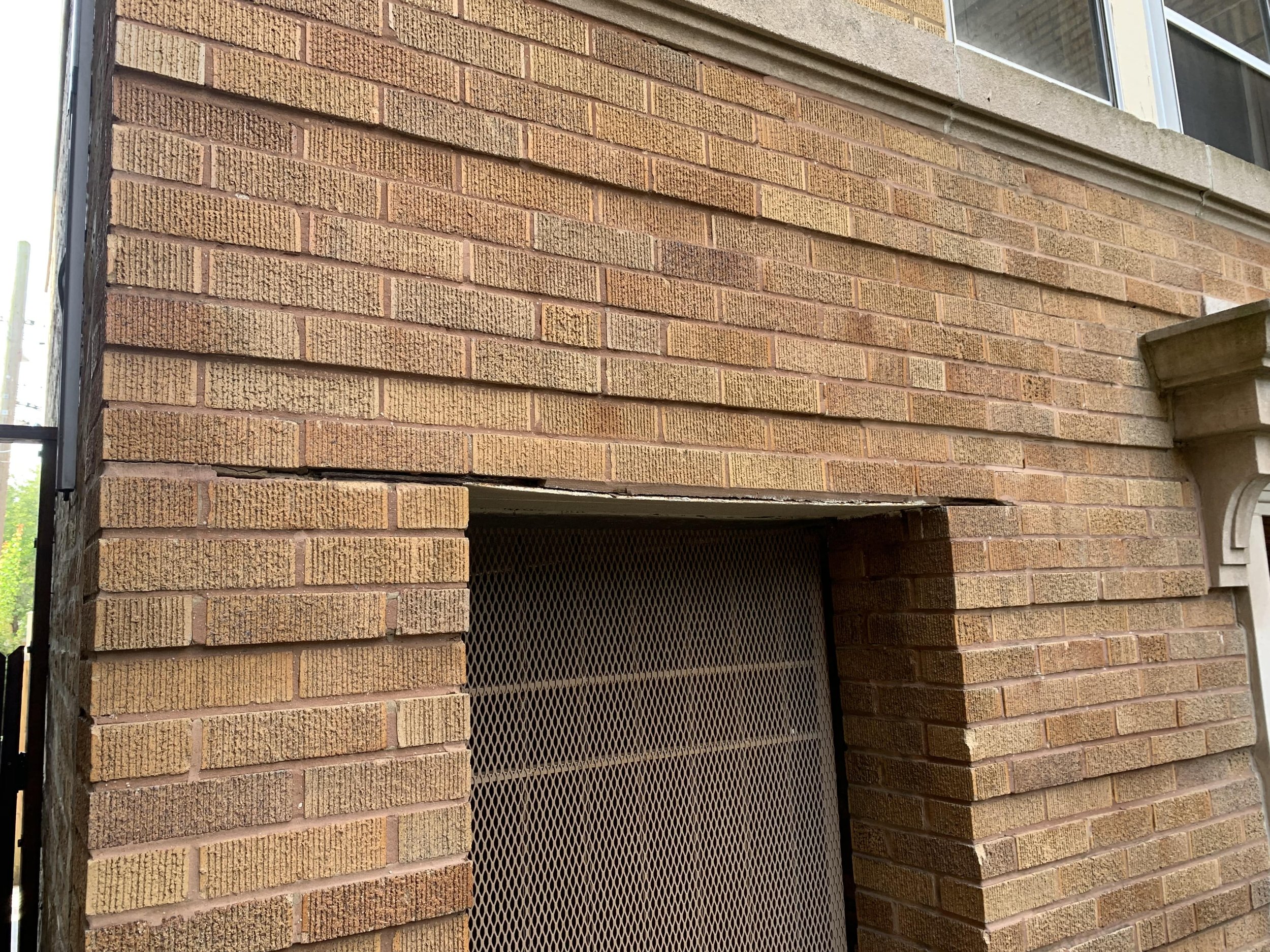 Sagging lintel beam with mortar cracks on Chicago building