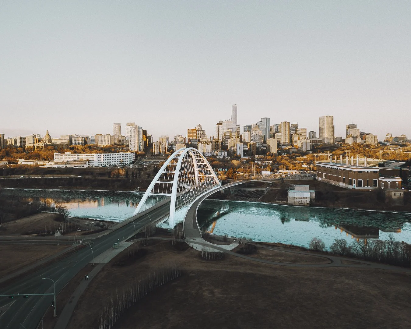 A beautiful aerial/drone shot of Walterdale bridge in Edmonton showing the city's skyline and North Saskatchewan River