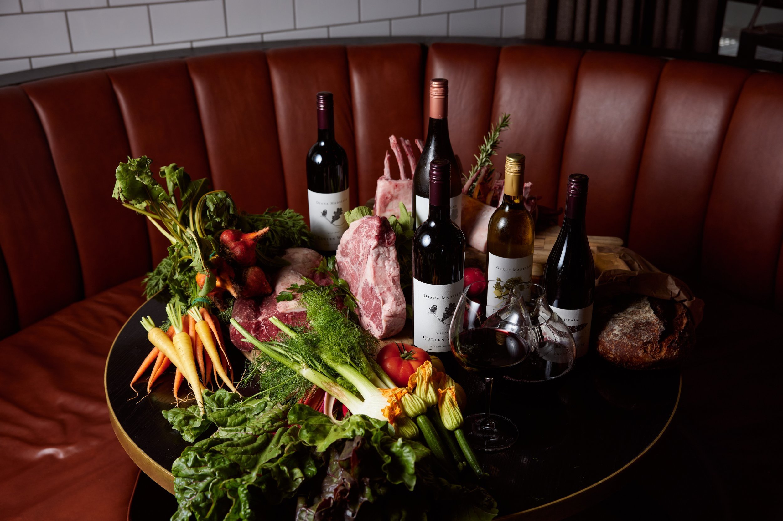 Table with fresh vegetables, meat and wine