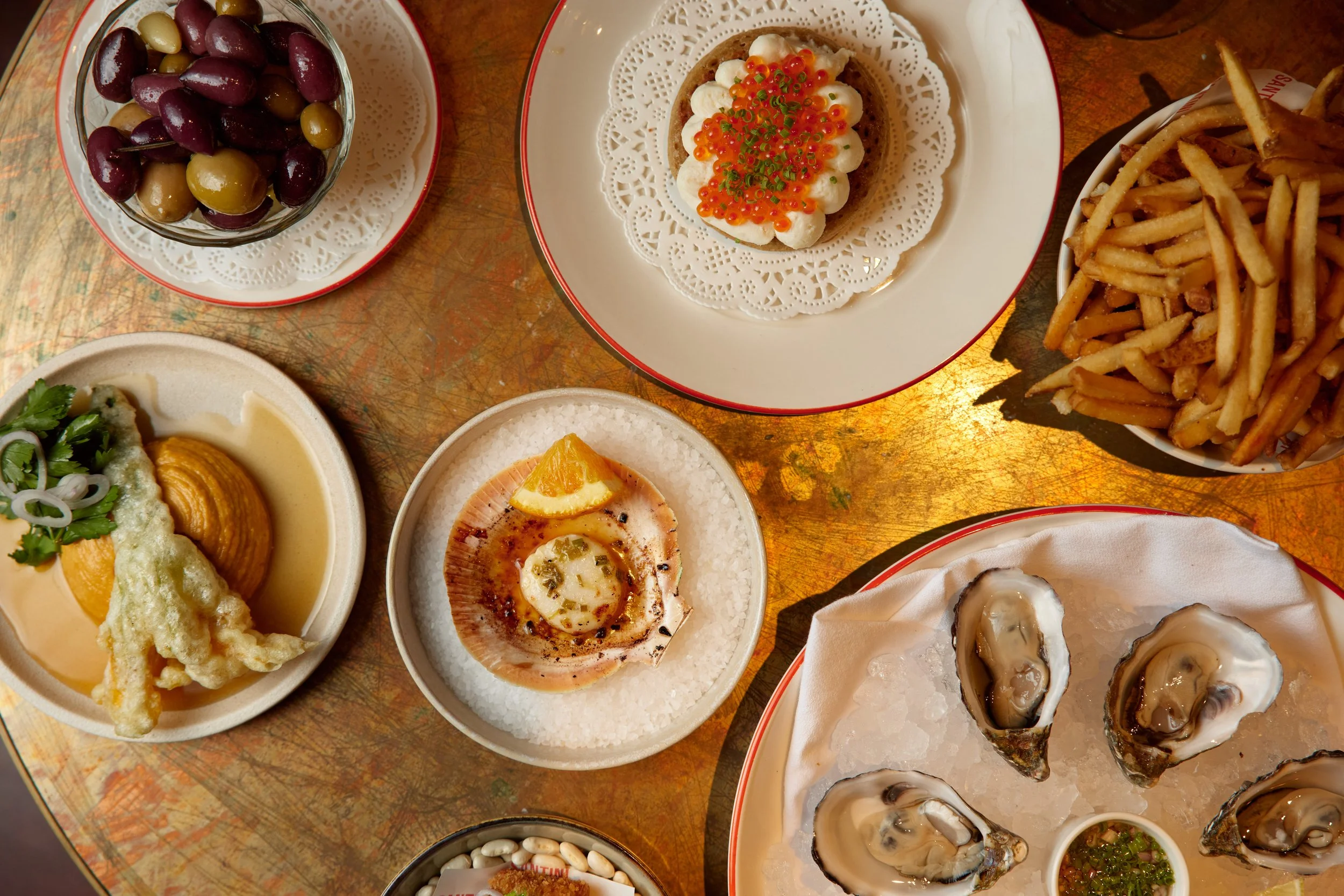 Small plates of snack food on a bronze table