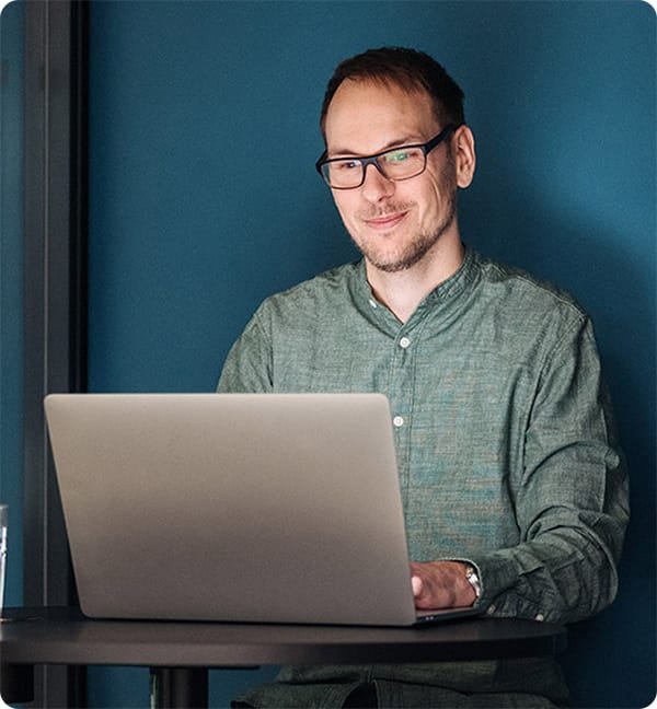 Porträt von Lennart Goschin, der an einem Laptop arbeitet