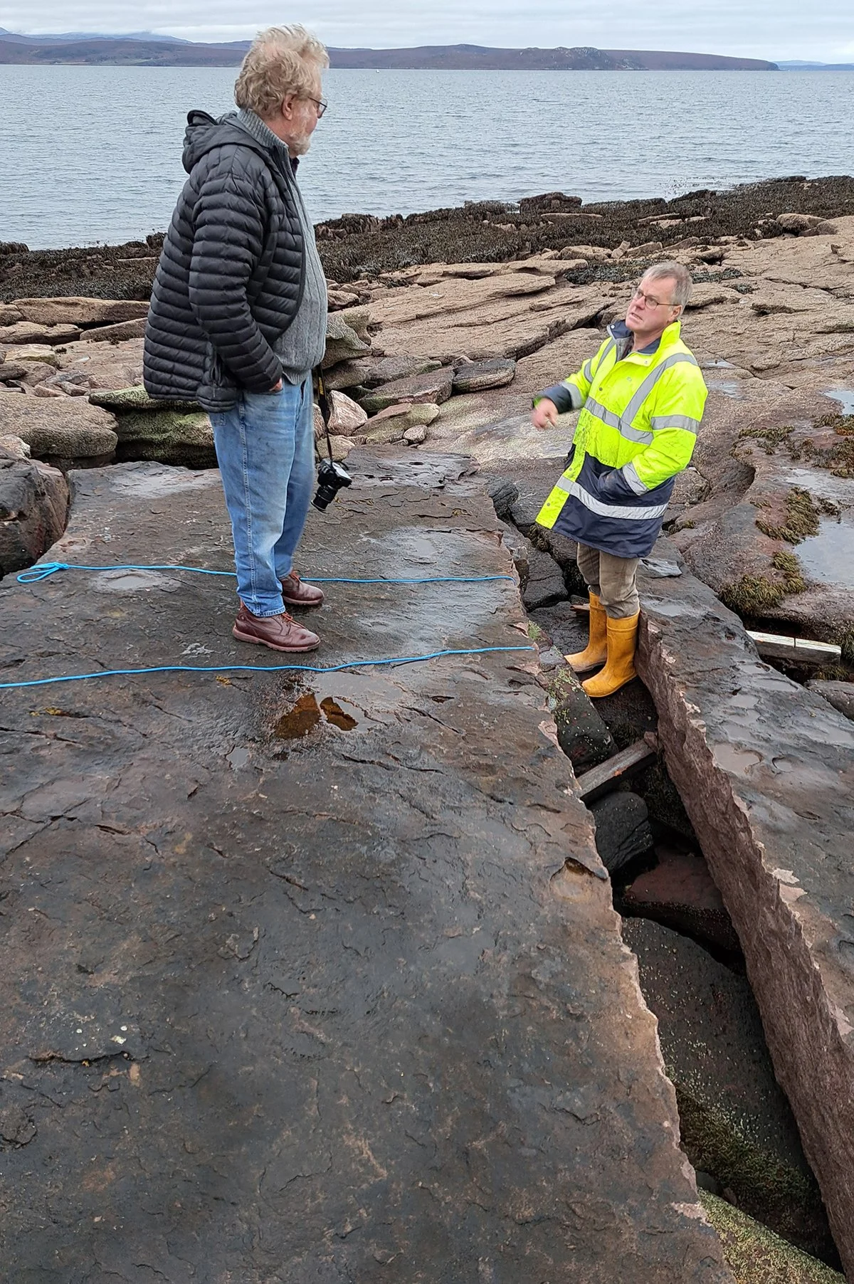 Will Maclean. artist, and Steve Husband, local volunteer, discuss the next stage of splitting the stone shelf at Achduart.