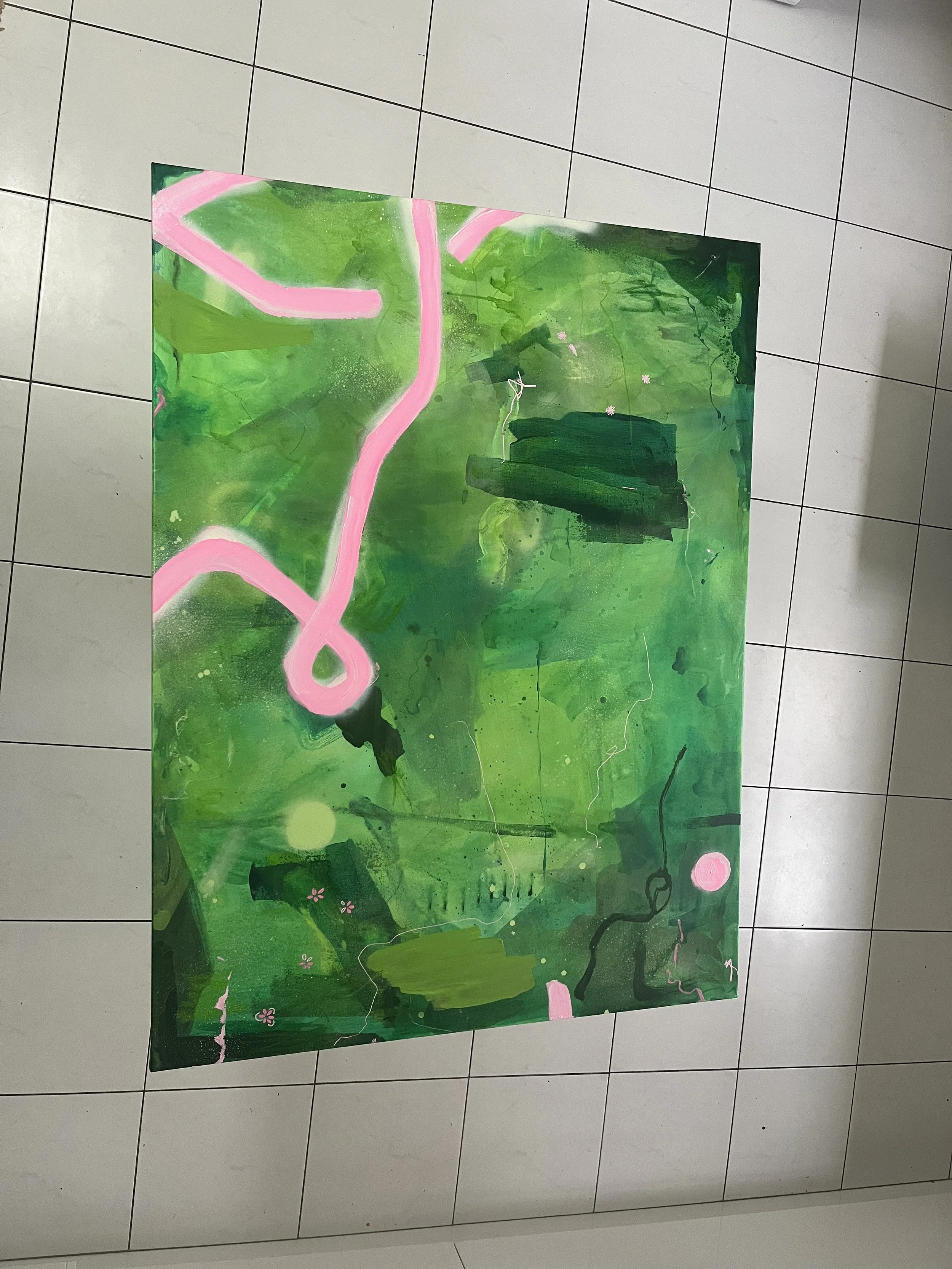 Abstract painting with shades of green, pink accents, small pink flowers, and black lines on a tiled floor.